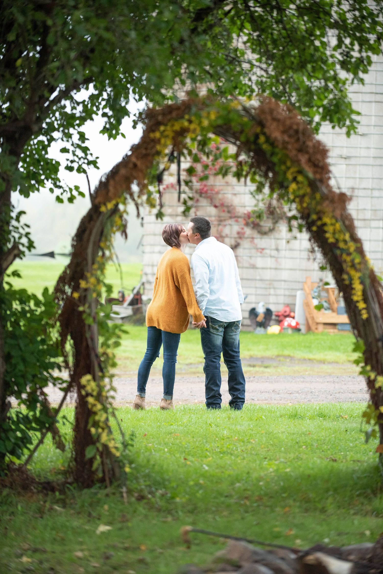 A romantic sequence of couples posing together under an archway of trees in a garden setting.
