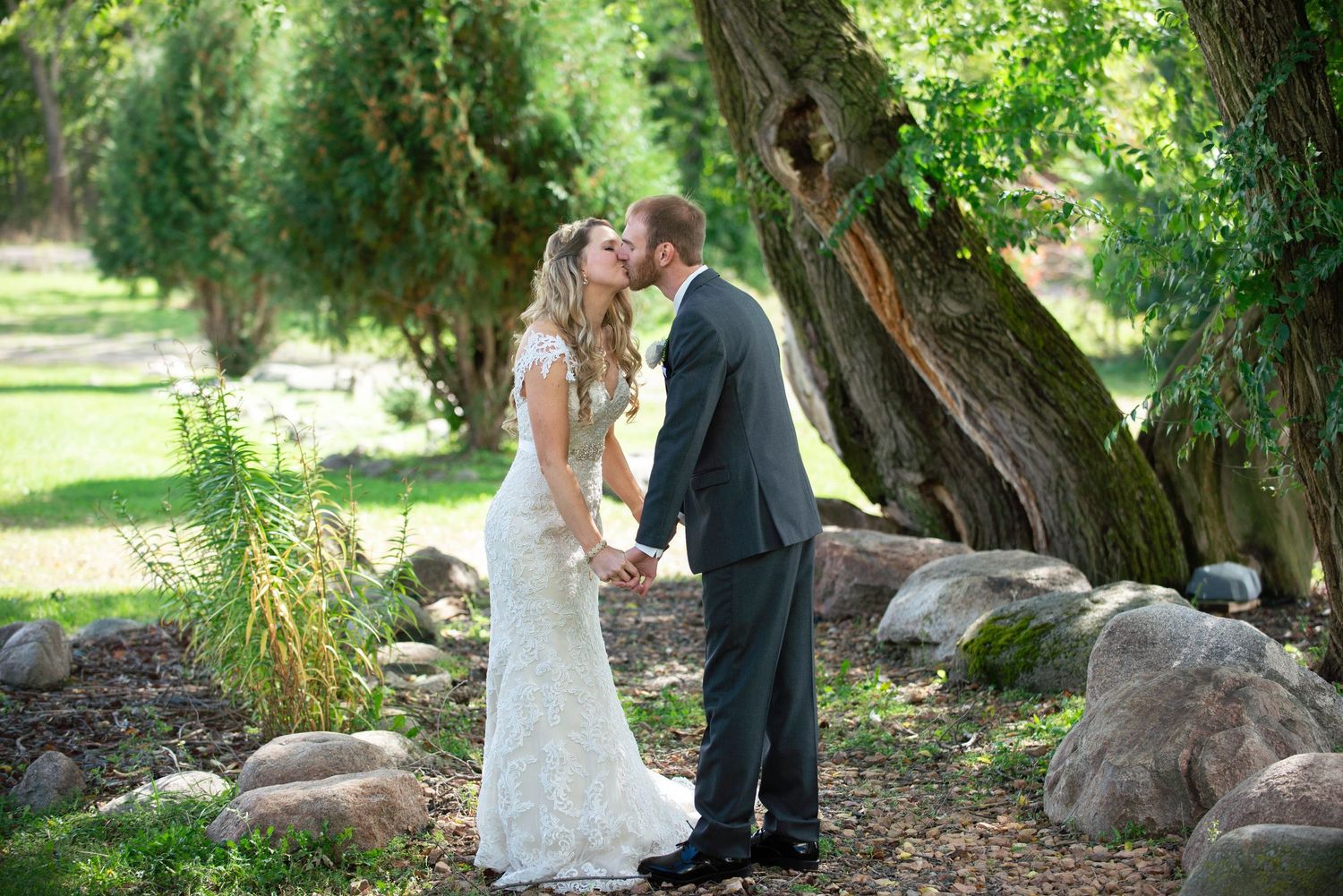Romantic wedding portraits taken under large trees in a natural outdoor setting. Rum River Barn Milaca Minnesota Weddings