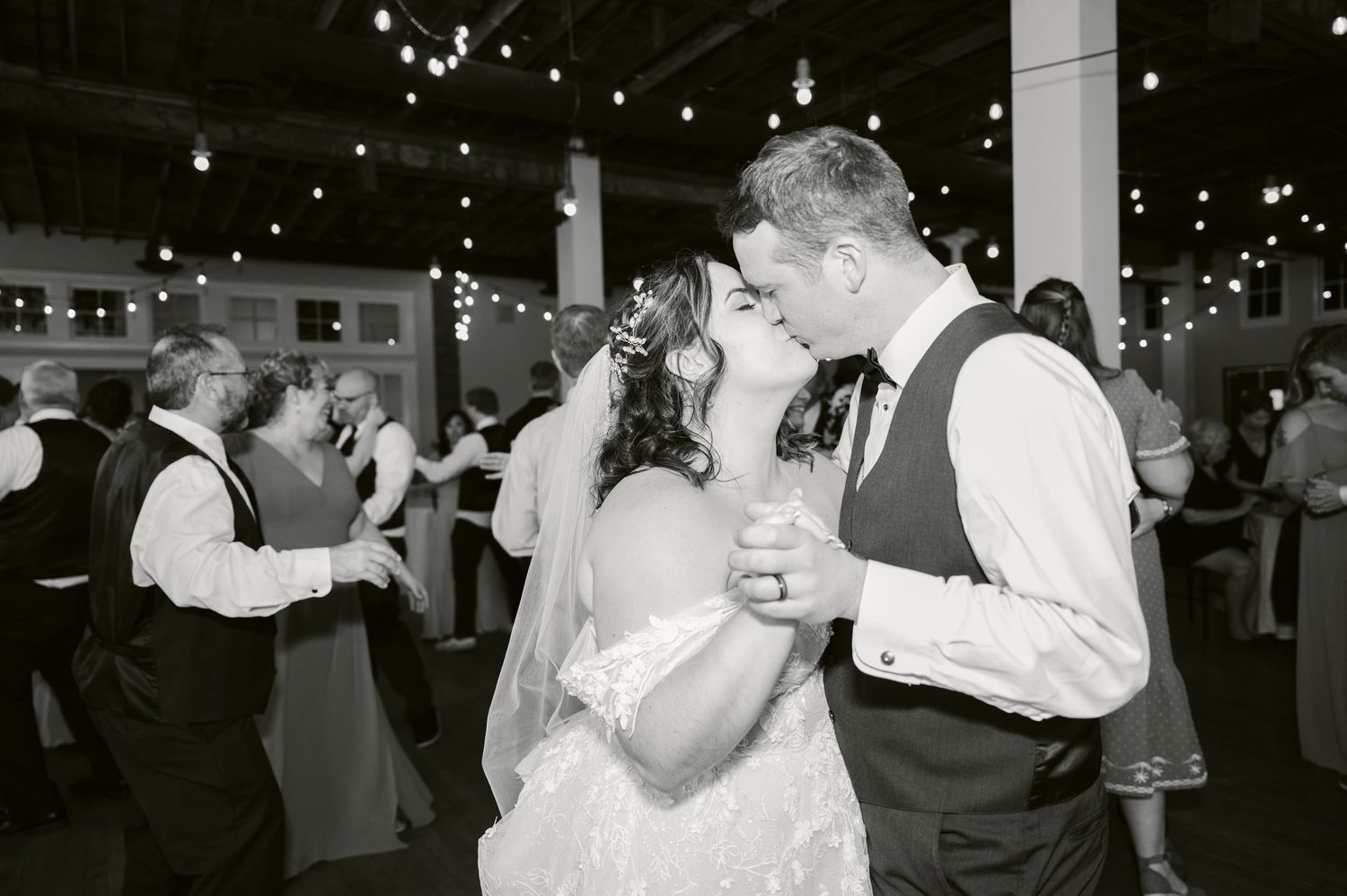 Wedding reception dance floor filled with joyful celebration under twinkling lights.