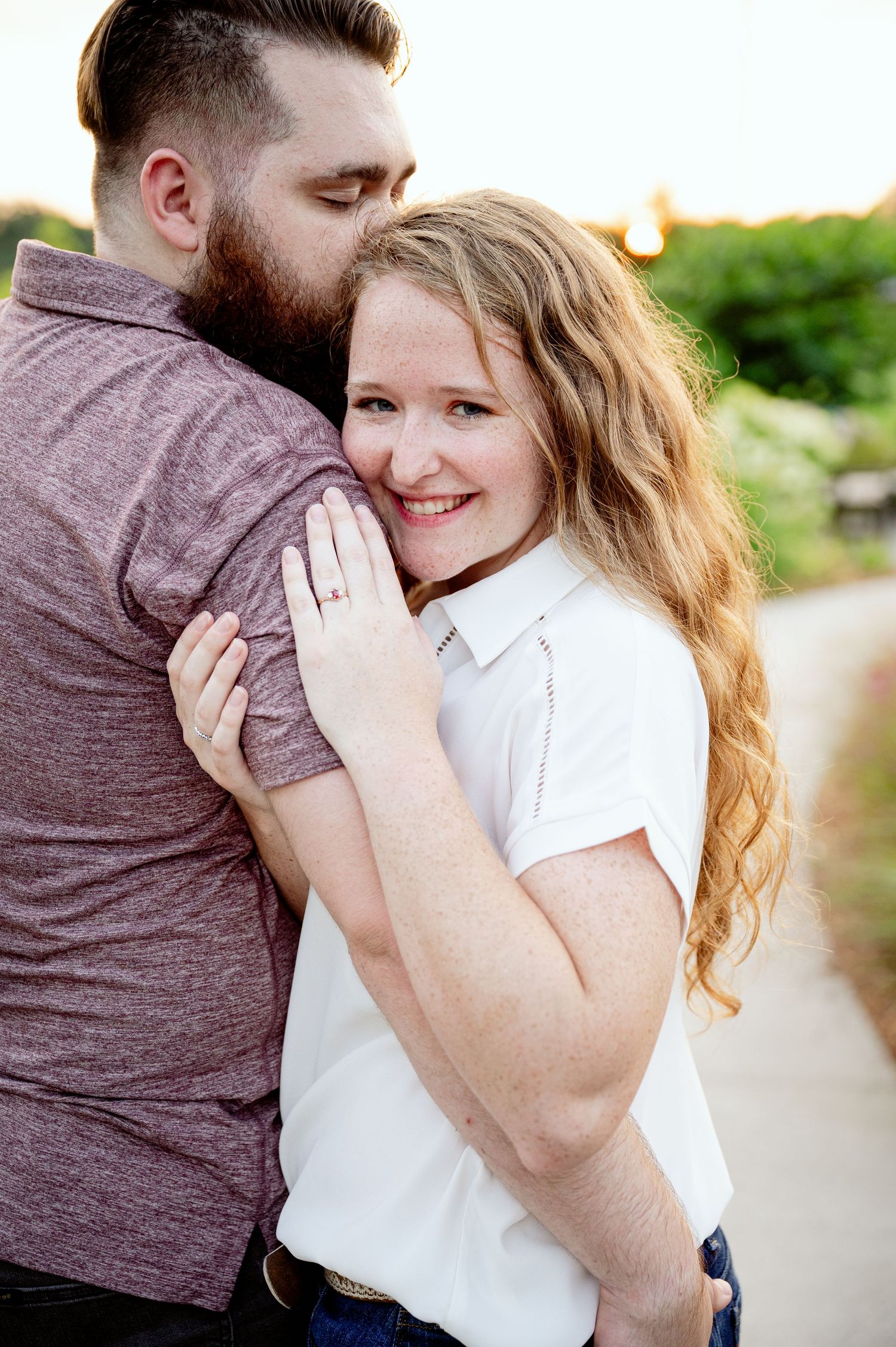 An engaged couple shares tender embraces during an outdoor engagement photoshoot.