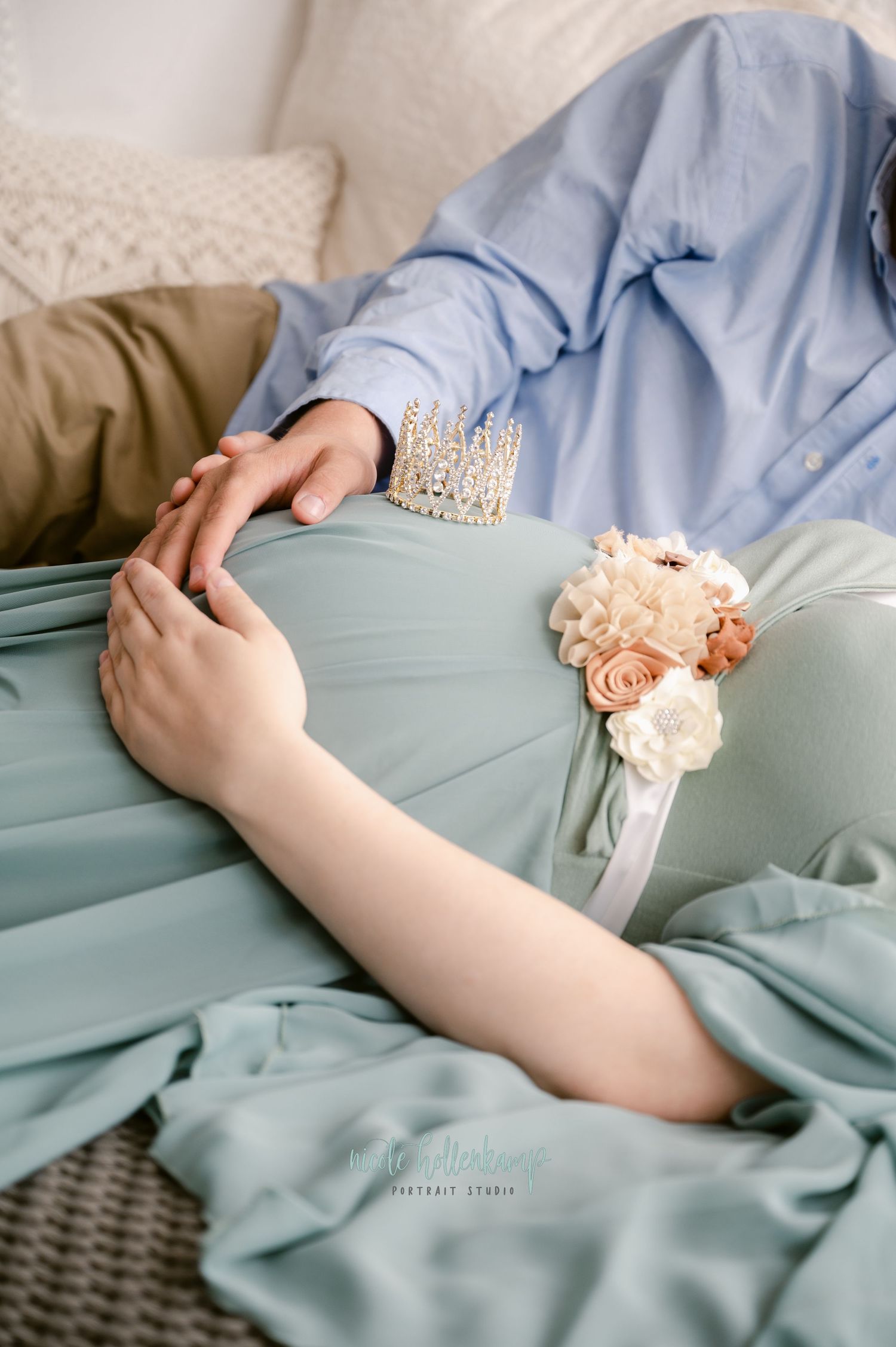Close-up of hands wearing a pearl bracelet with a peach and white floral corsage against a soft blue dress.