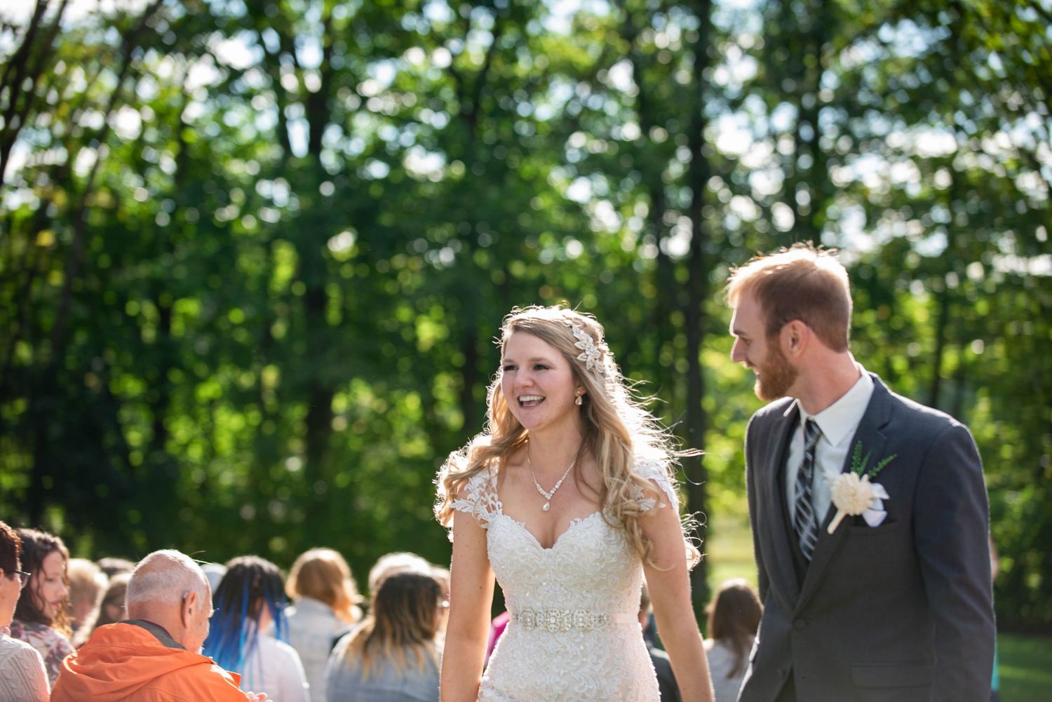 A joyous wedding celebration unfolds in a lush green outdoor garden setting. Rum River Barn Milaca Minnesota Weddings