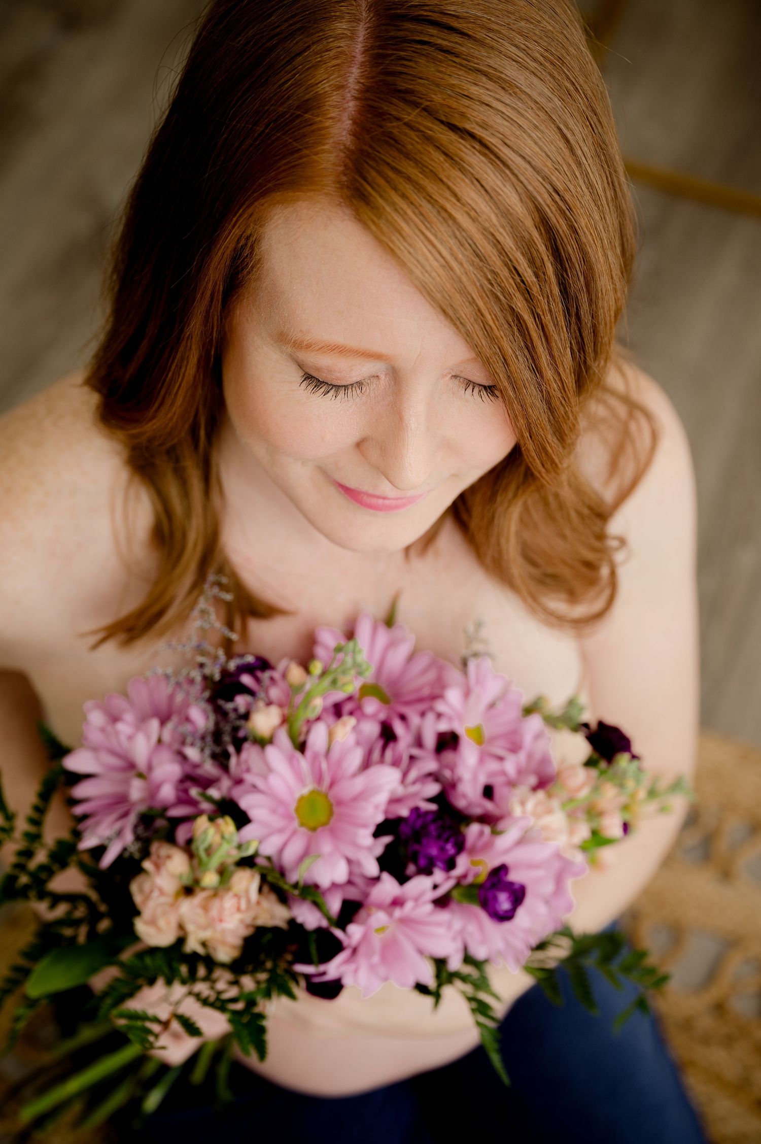 A soft portrait series showing someone delicately posed with fresh pink and purple chrysanthemums and florals.