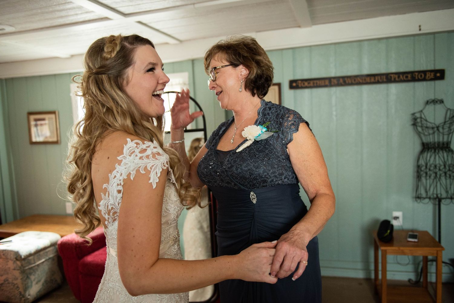 Two people in formal attire share a joyous laugh together during a special occasion.