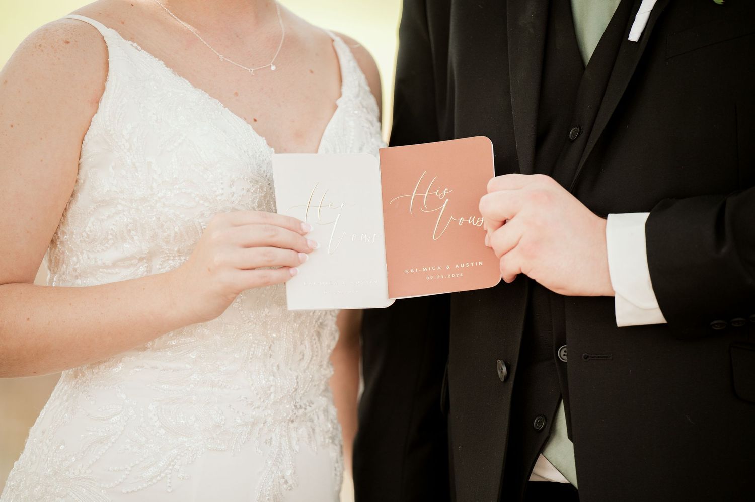 The Grands At Mulligans. Private vows Two newlyweds in black and white formal attire hold vow books during a private vow reading.