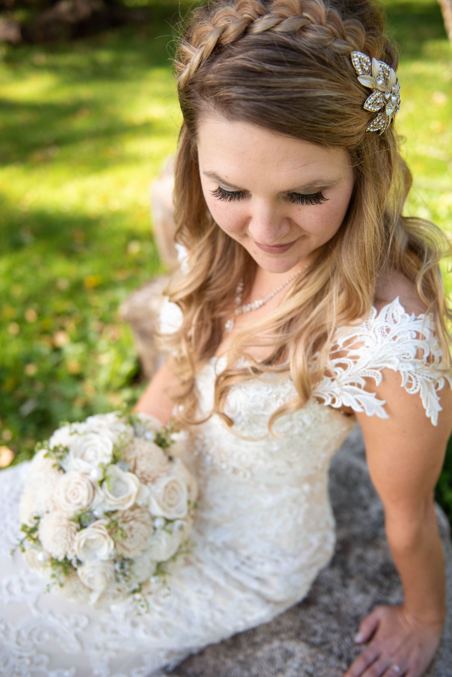 Close up portrait of bridal details showing lace dress, floral hair accessory and white rose bouquet. Rum River Barn Milaca Minnesota Weddin