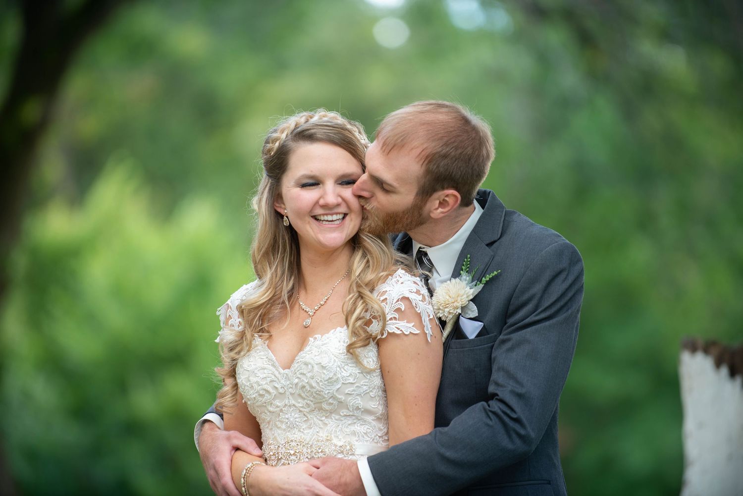 A romantic wedding moment captured between newlyweds in a lush garden setting. Rum River Barn Milaca Minnesota Weddings