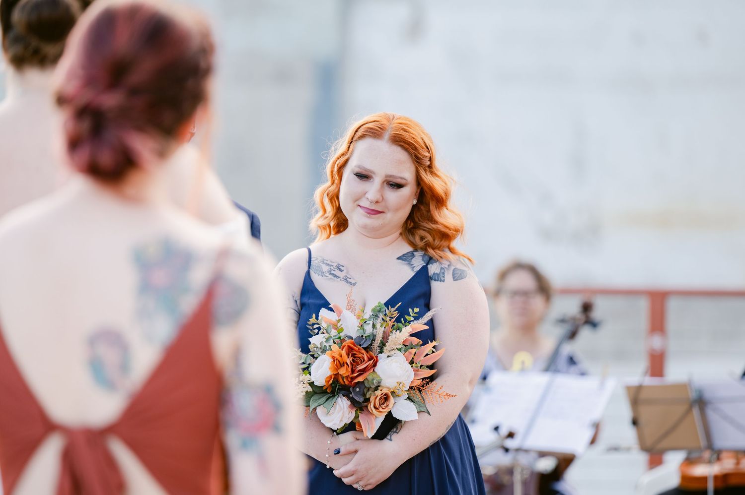 Pier B Duluth Wedding Wedding party members in formal attire on outdoor deck with decorative floral arrangements.