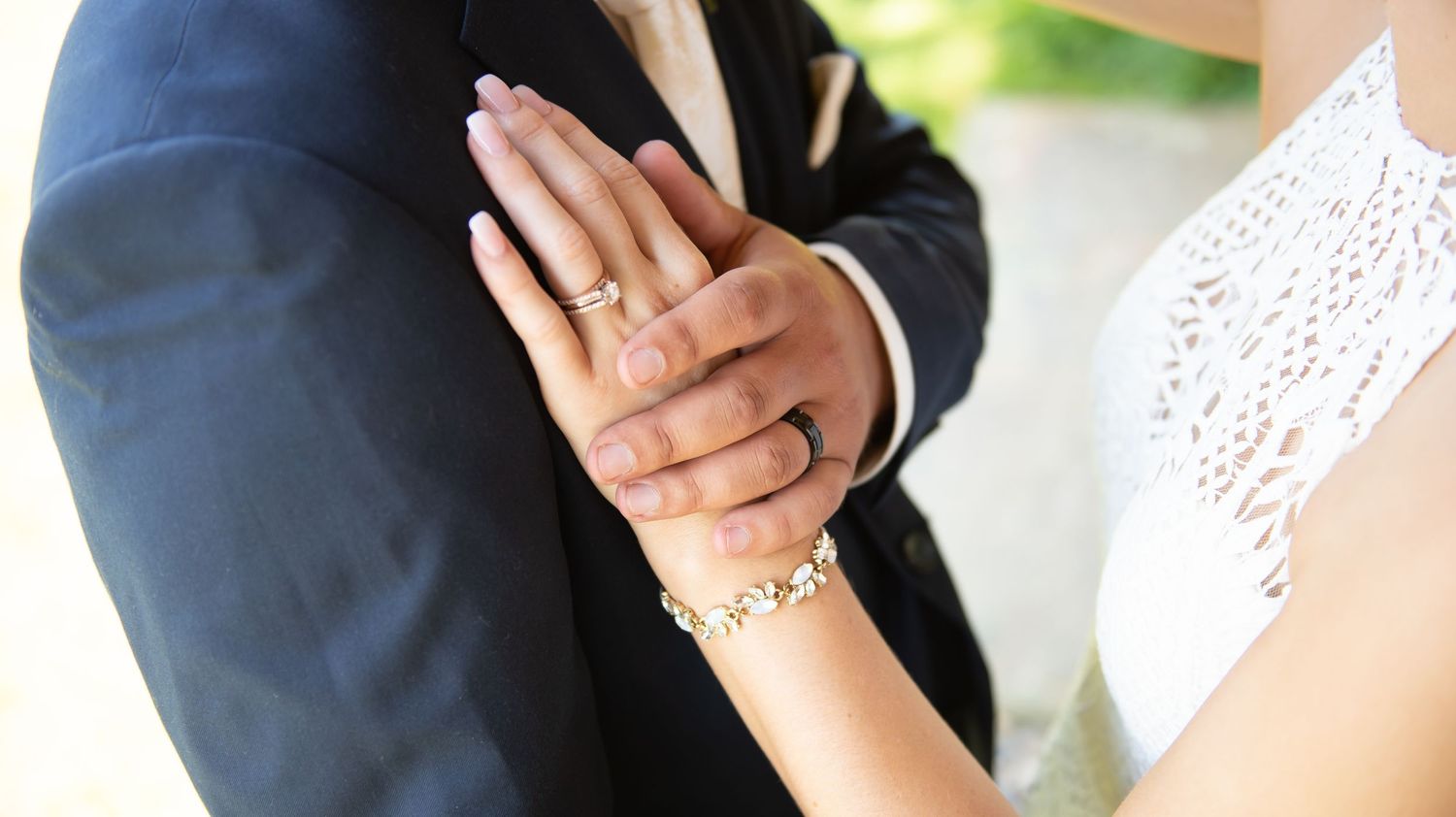 A close-up view of an ornate lace and beaded wedding dress detail, highlighting the delicate fabric patterns.