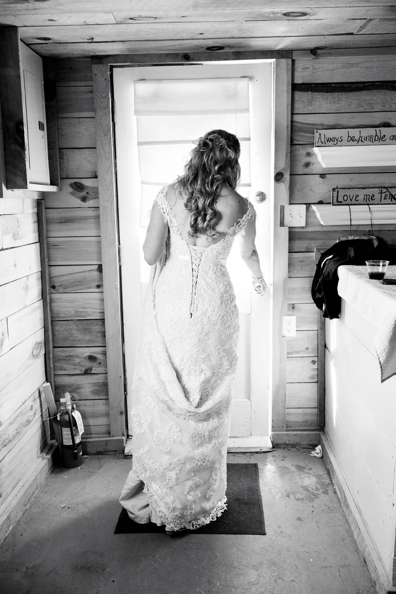 Series of artistic black and white photos showing a wedding dress against rustic wooden walls. Rum River Barn Milaca Minnesota Weddings