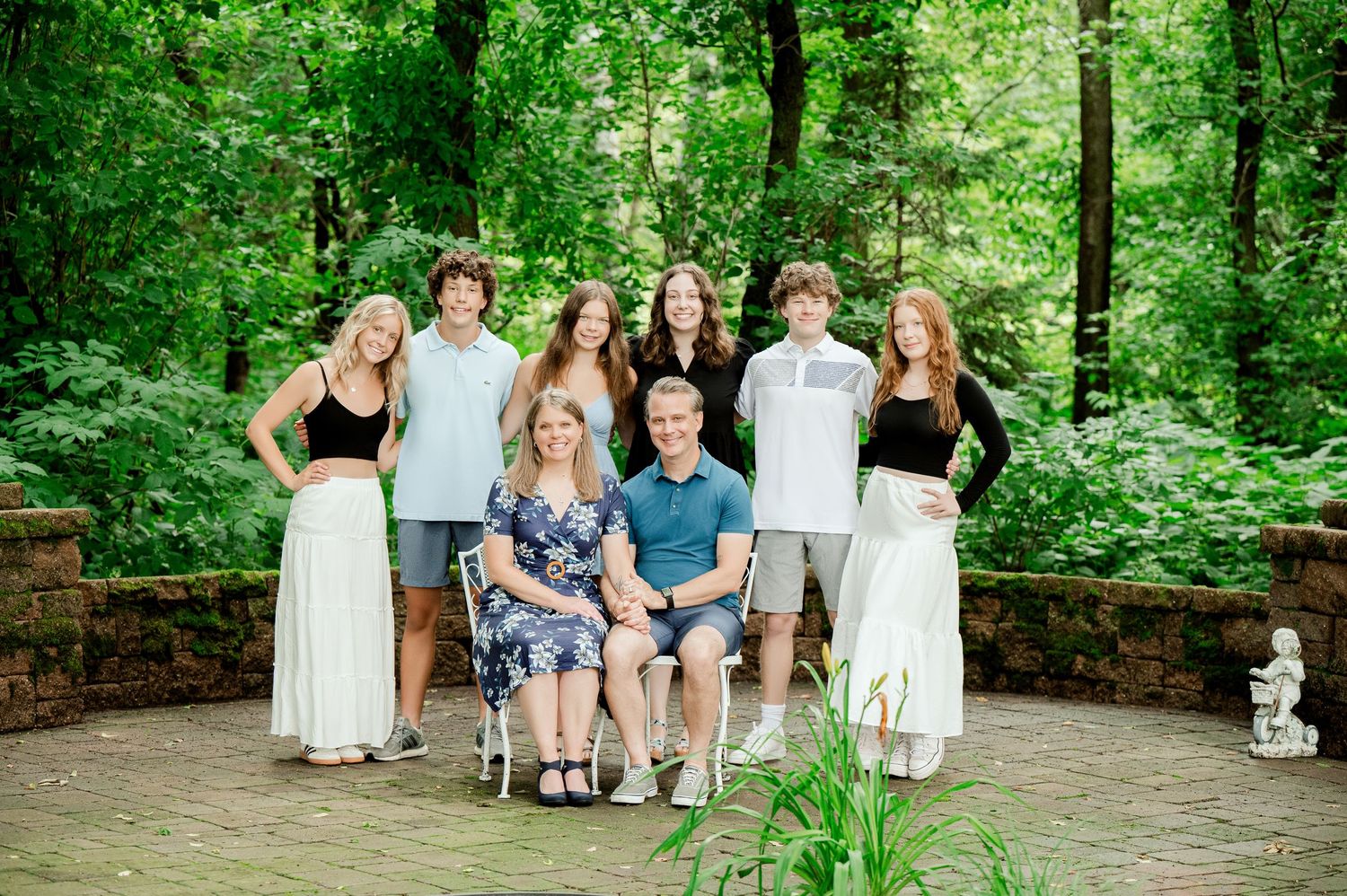 Clear Lake Family Photography: sit on stone steps surrounded by lush green forest during a summer photo session outdoors.