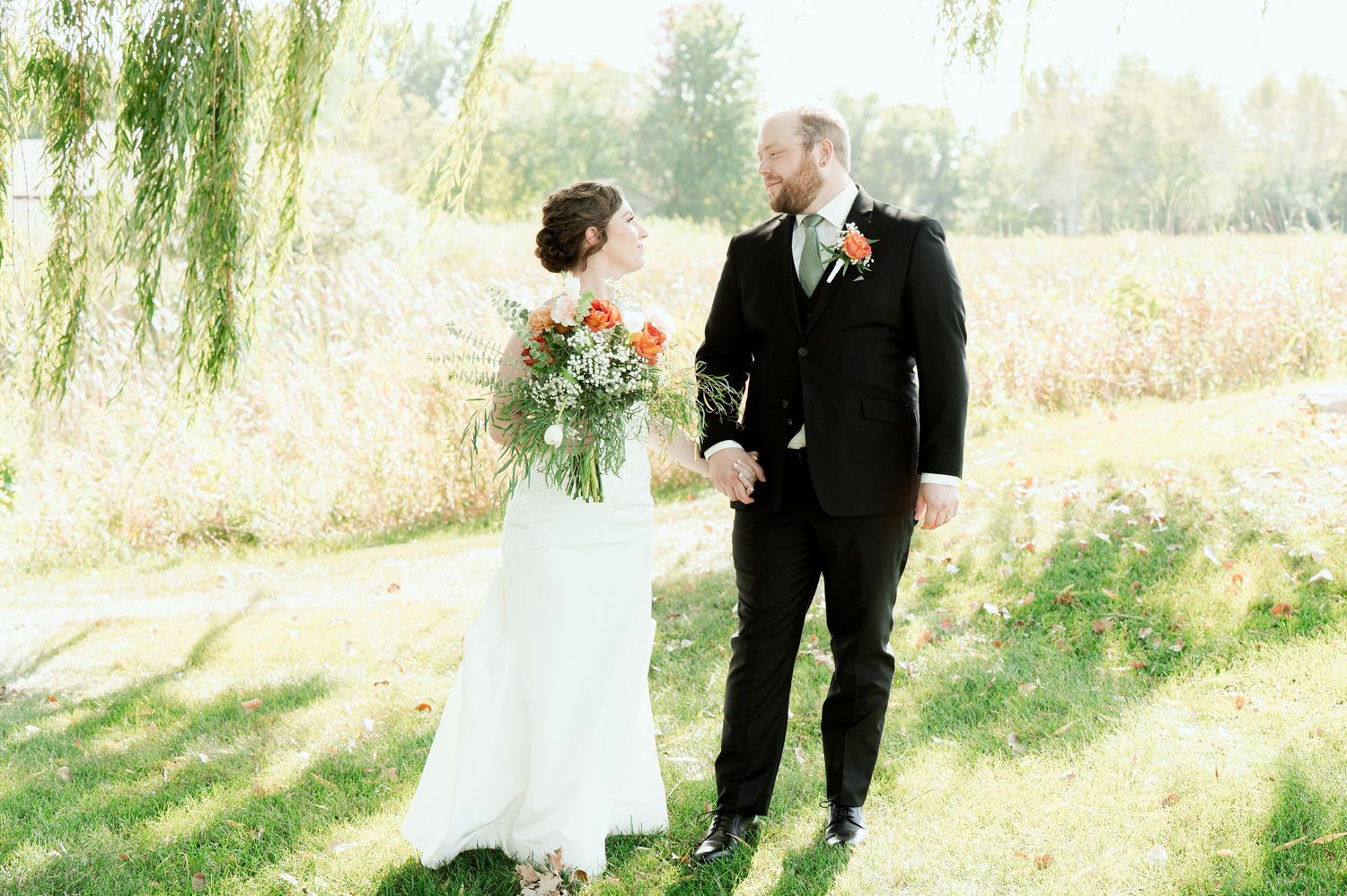 Romantic wedding moment captured in a sunlit garden setting with natural greenery.