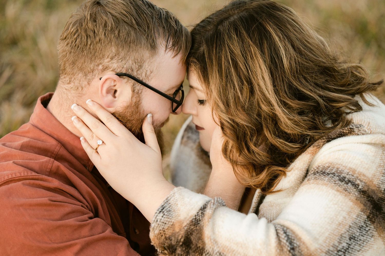 Two people share a tender romantic moment while kissing outdoors with soft natural lighting. St cloud area engagement photos.
