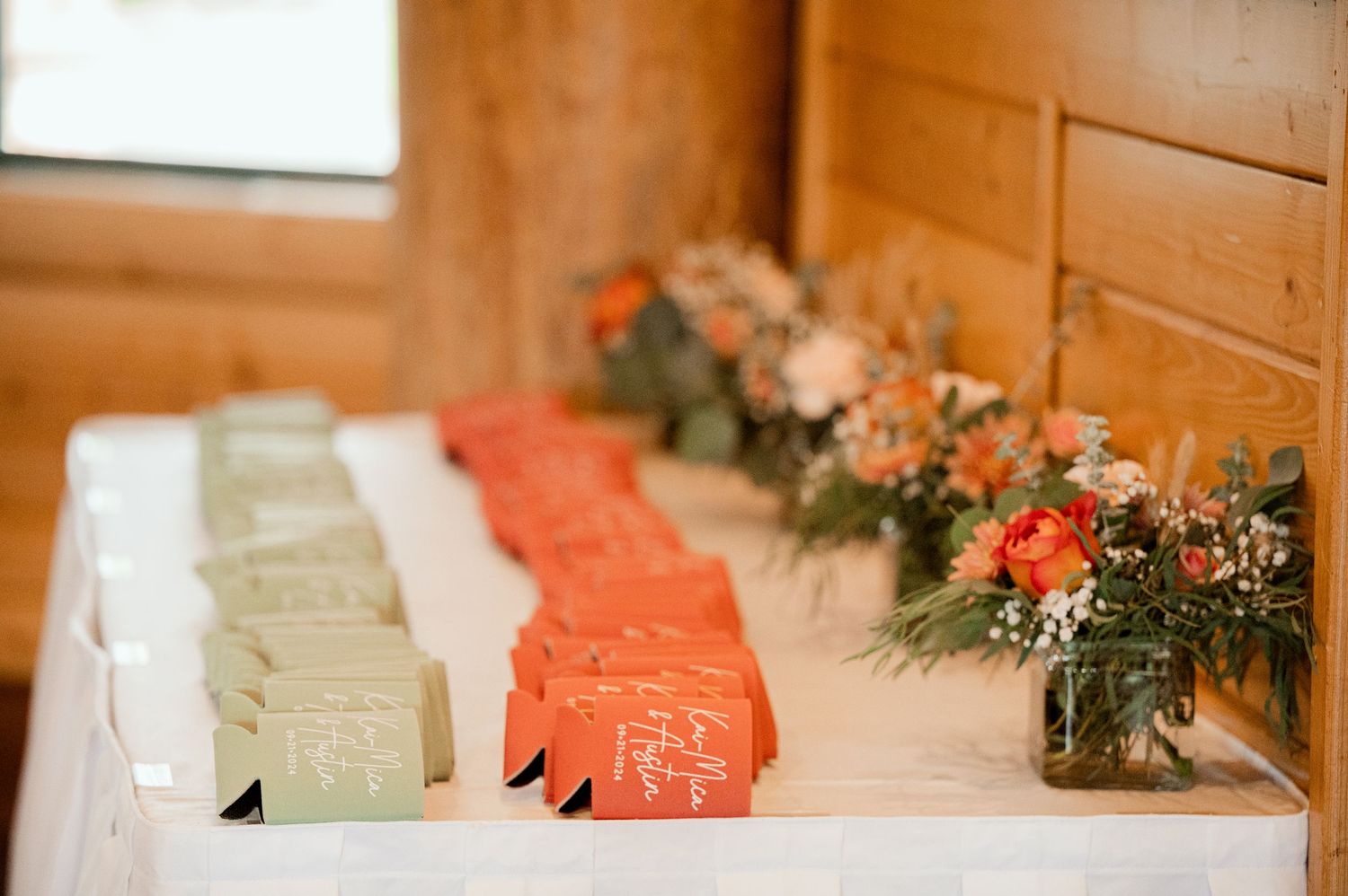 The Grands at Mulligans- Wedding Photos: details pastel green and coral colors displayed on a wooden surface with decorative foliage.