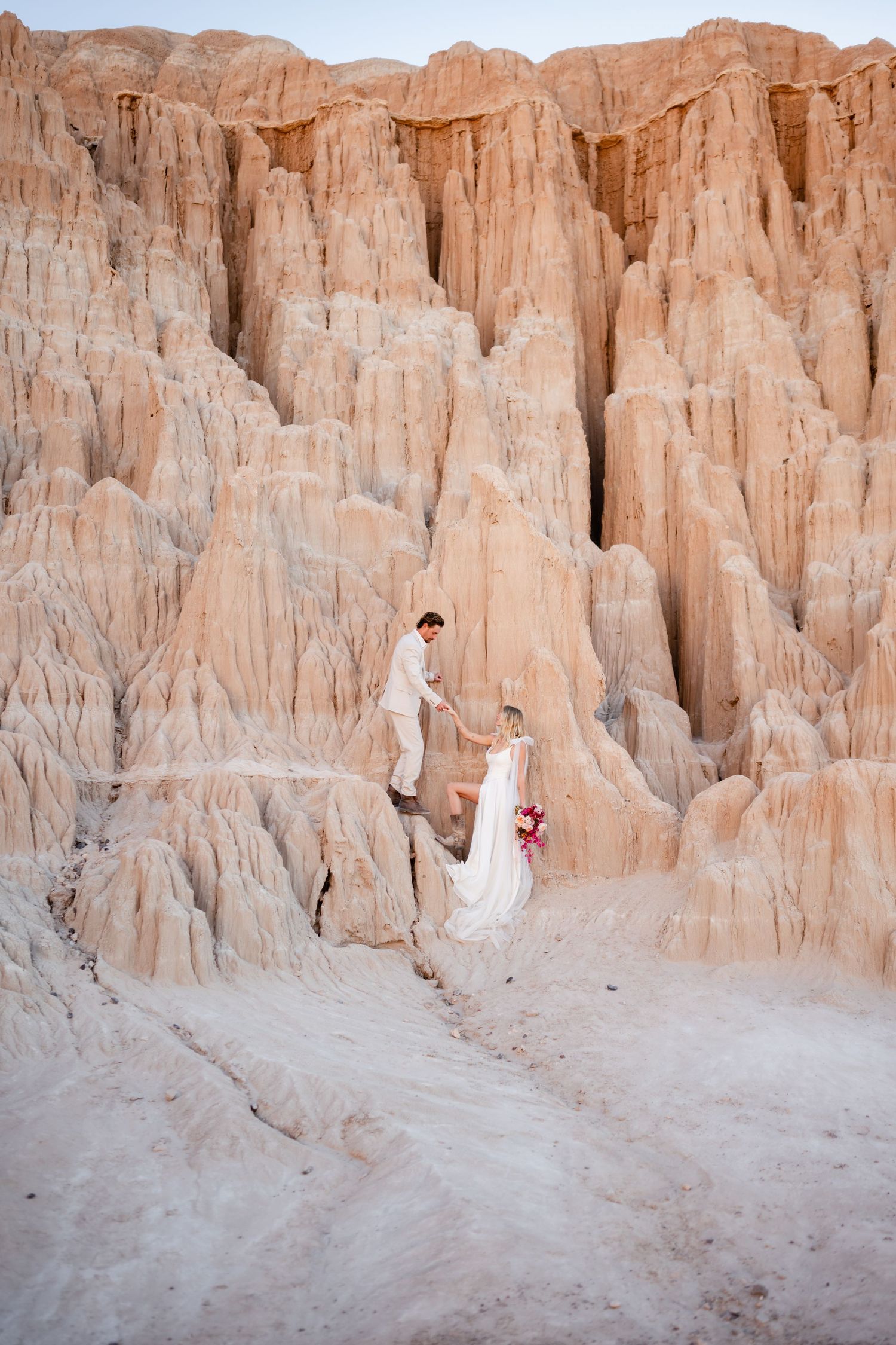 Elopement couple climbs the rocks of Cathedral Gorge with Utah Elopement photographer Coley Cook