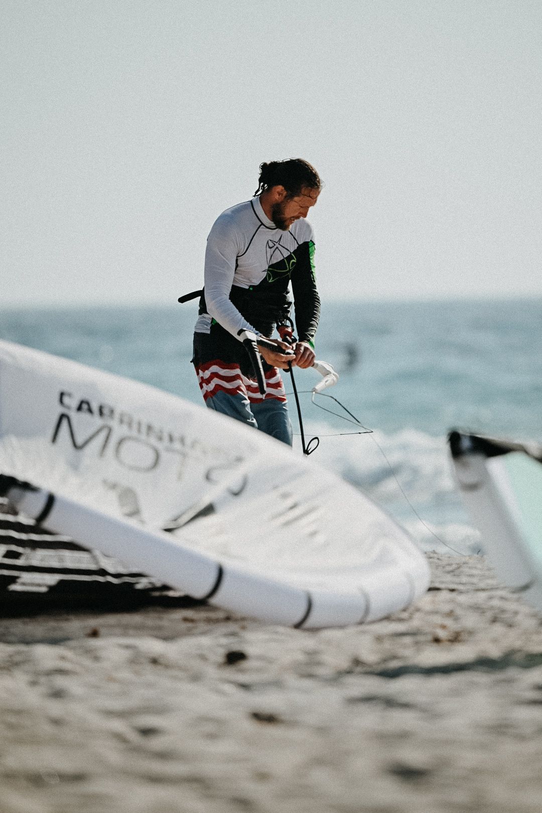 A man preparing a kite on a beach in Mastichari, Greece