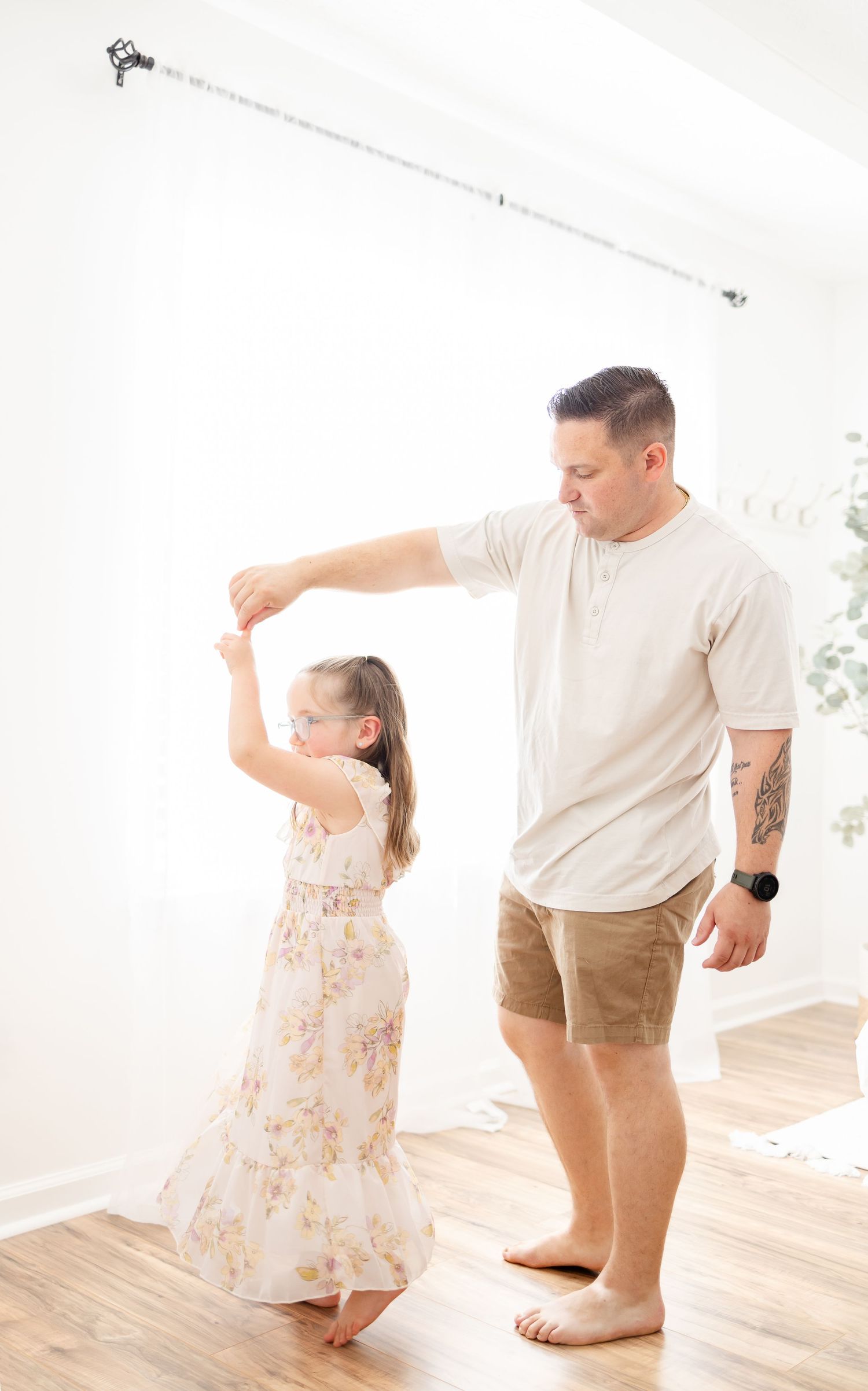 A sweet dance sequence shows a parent and child swaying together in a bright sunlit room.