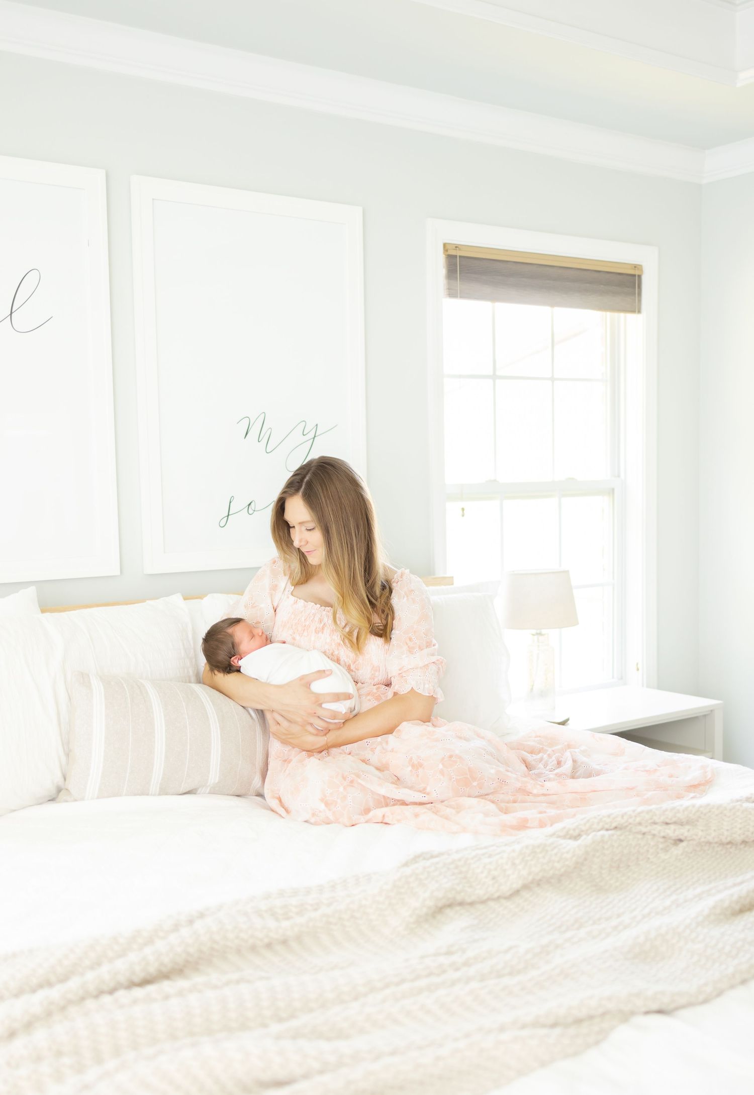 A peaceful nursery scene with soft natural light streaming through a window, featuring tender moments in a white bedroom.