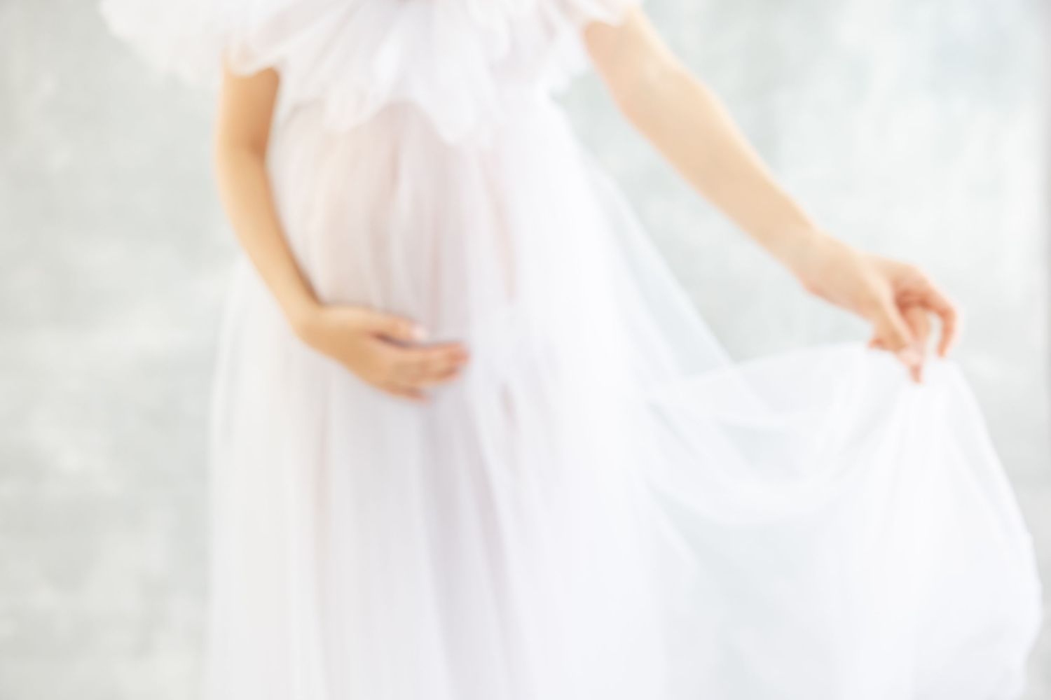 A bride in a white tulle wedding dress twirls gracefully, creating an ethereal swirling effect with her gown.