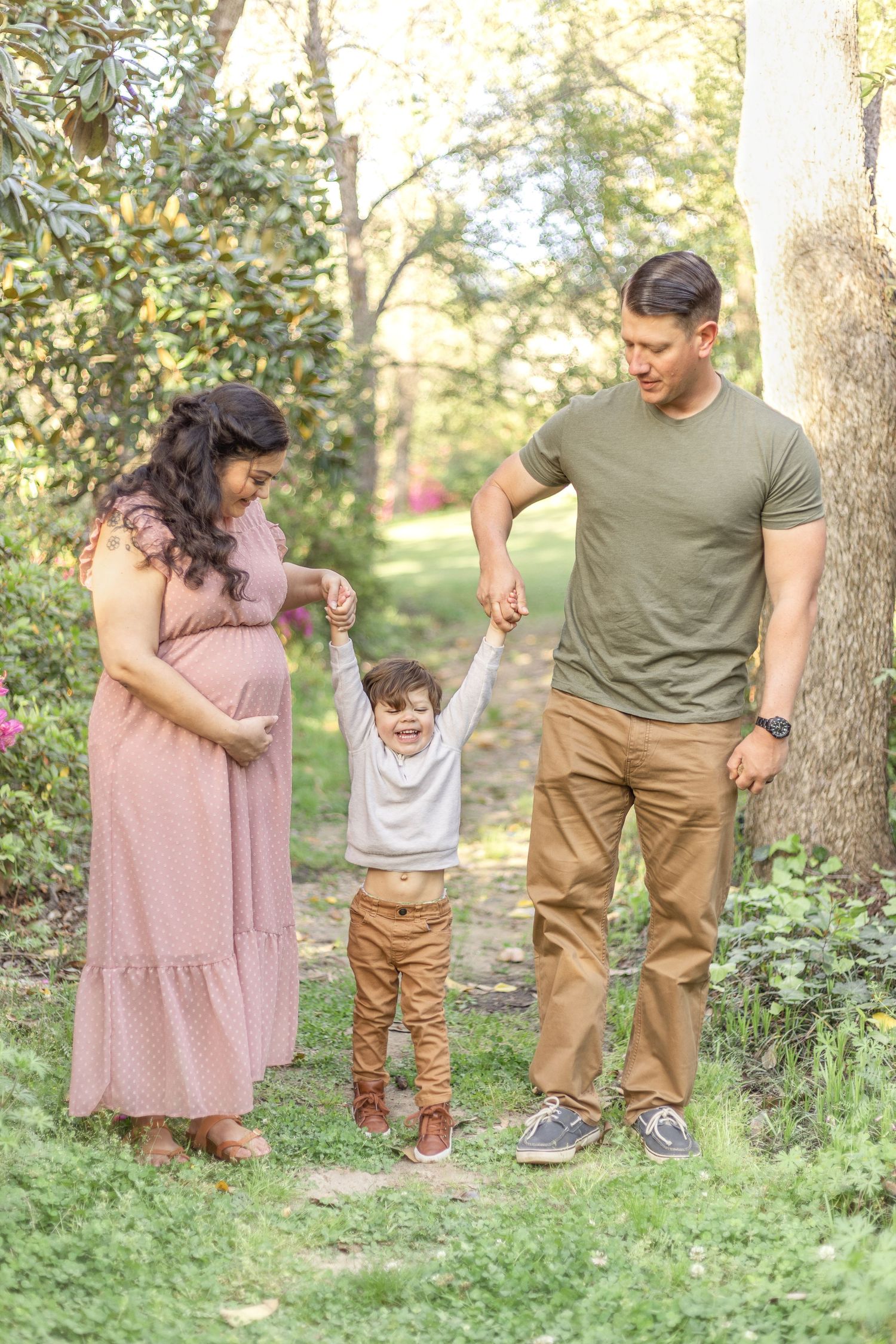 A family spends time together outdoors in a wooded setting wearing coordinated casual outfits.