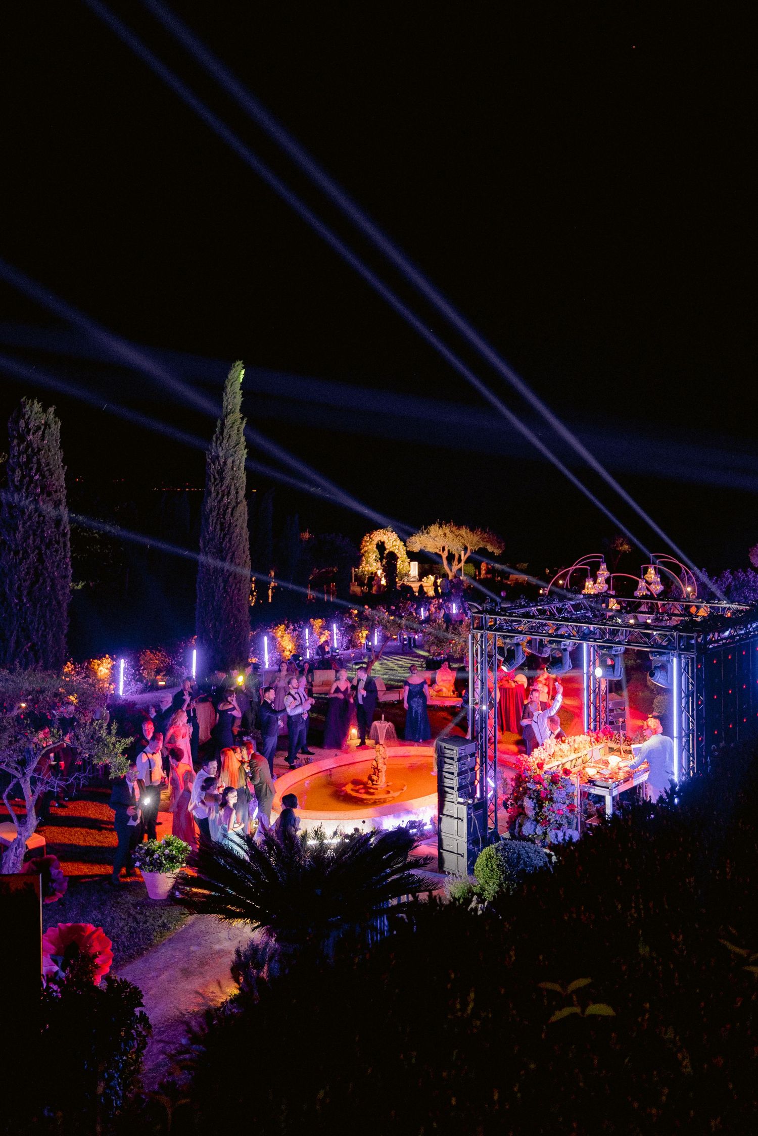 Vibrant outdoor Villa Cimbrone setting with blue spotlights, red ambient lighting, and palm trees creating a tropical party atmosphere.