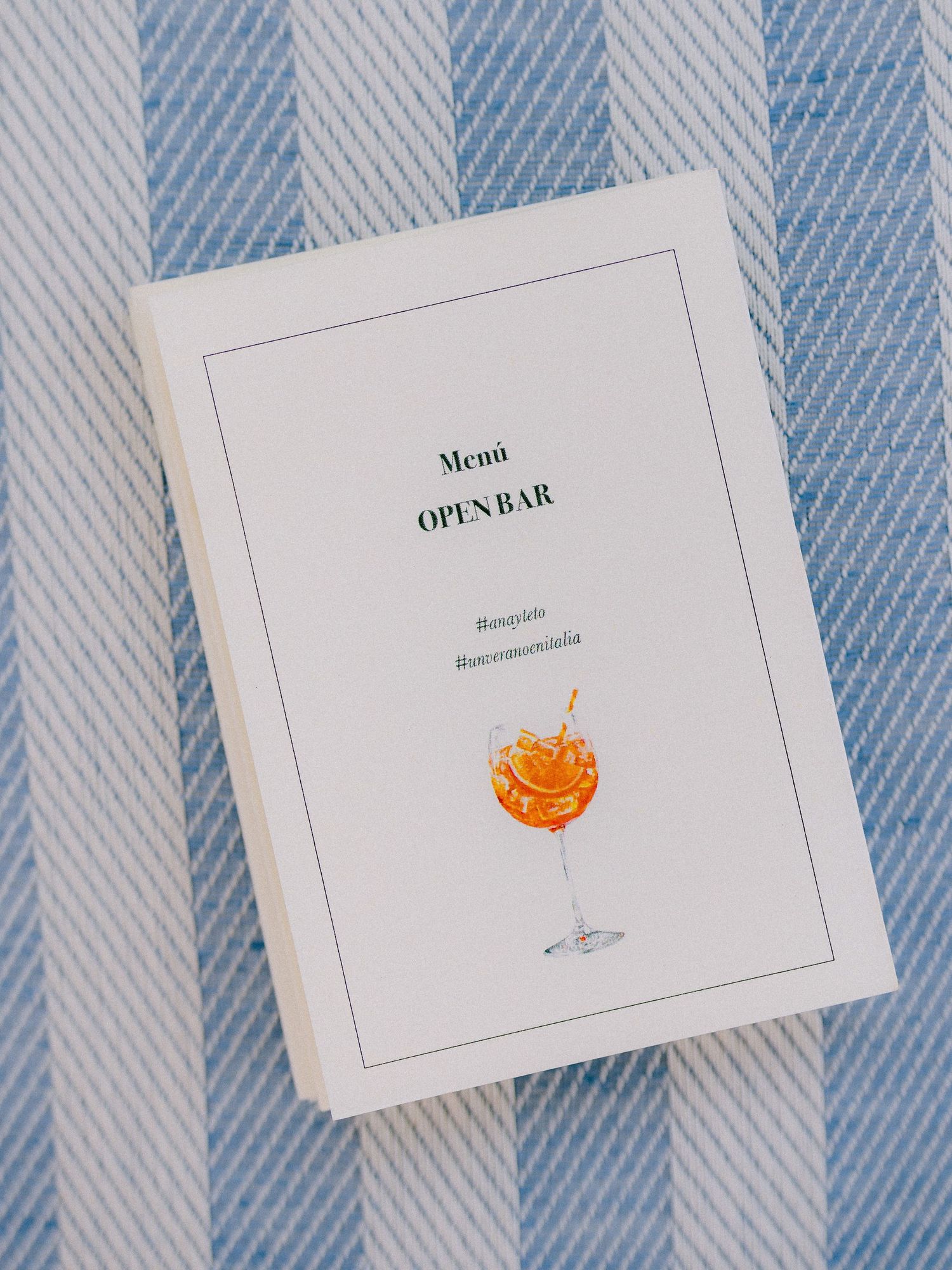 A menu or book cover with 'Open Bar' text sits on a blue and white striped background with an orange cocktail illustration.