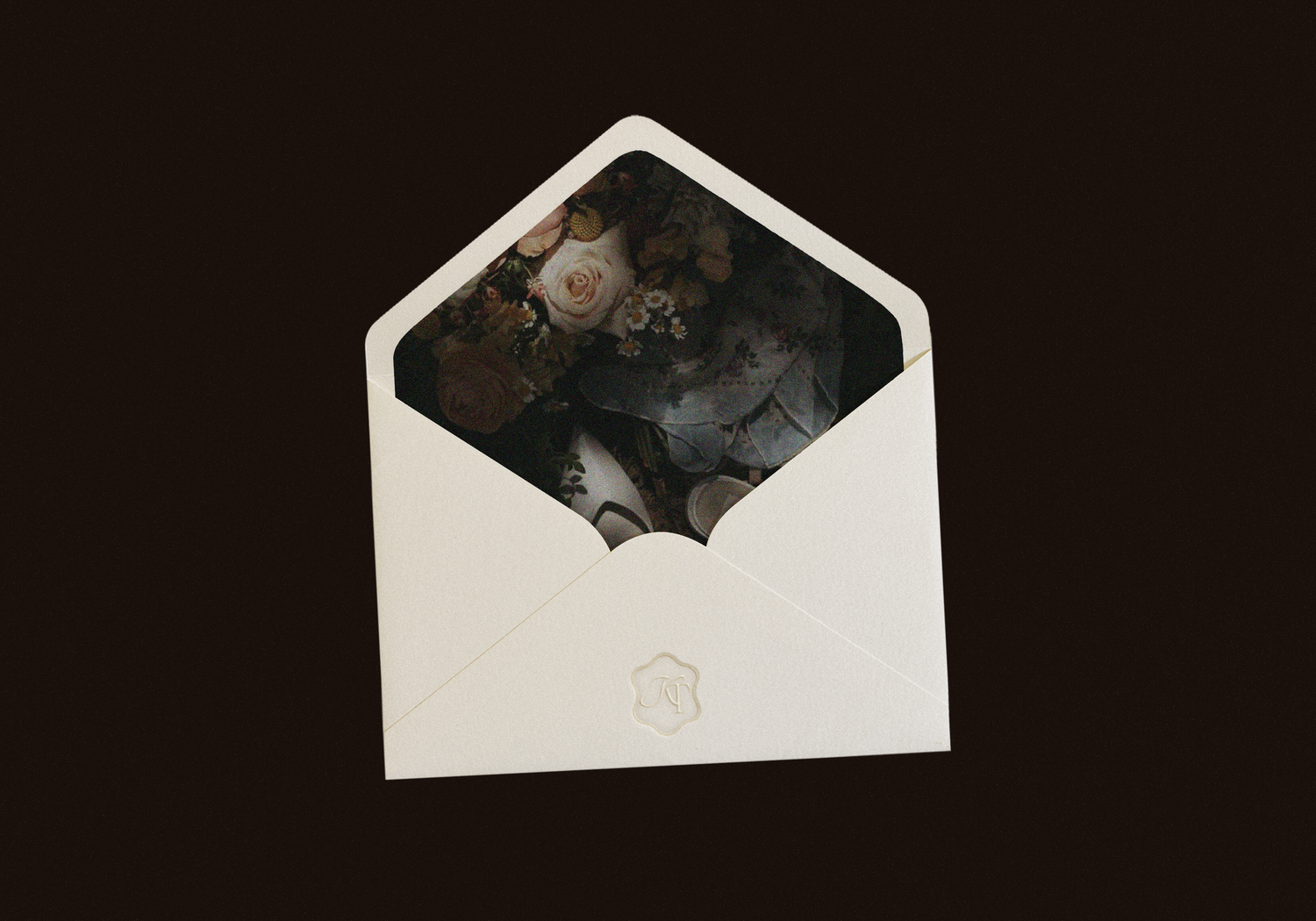 A white envelope with vintage black and white photographs spilling out against a dark background.