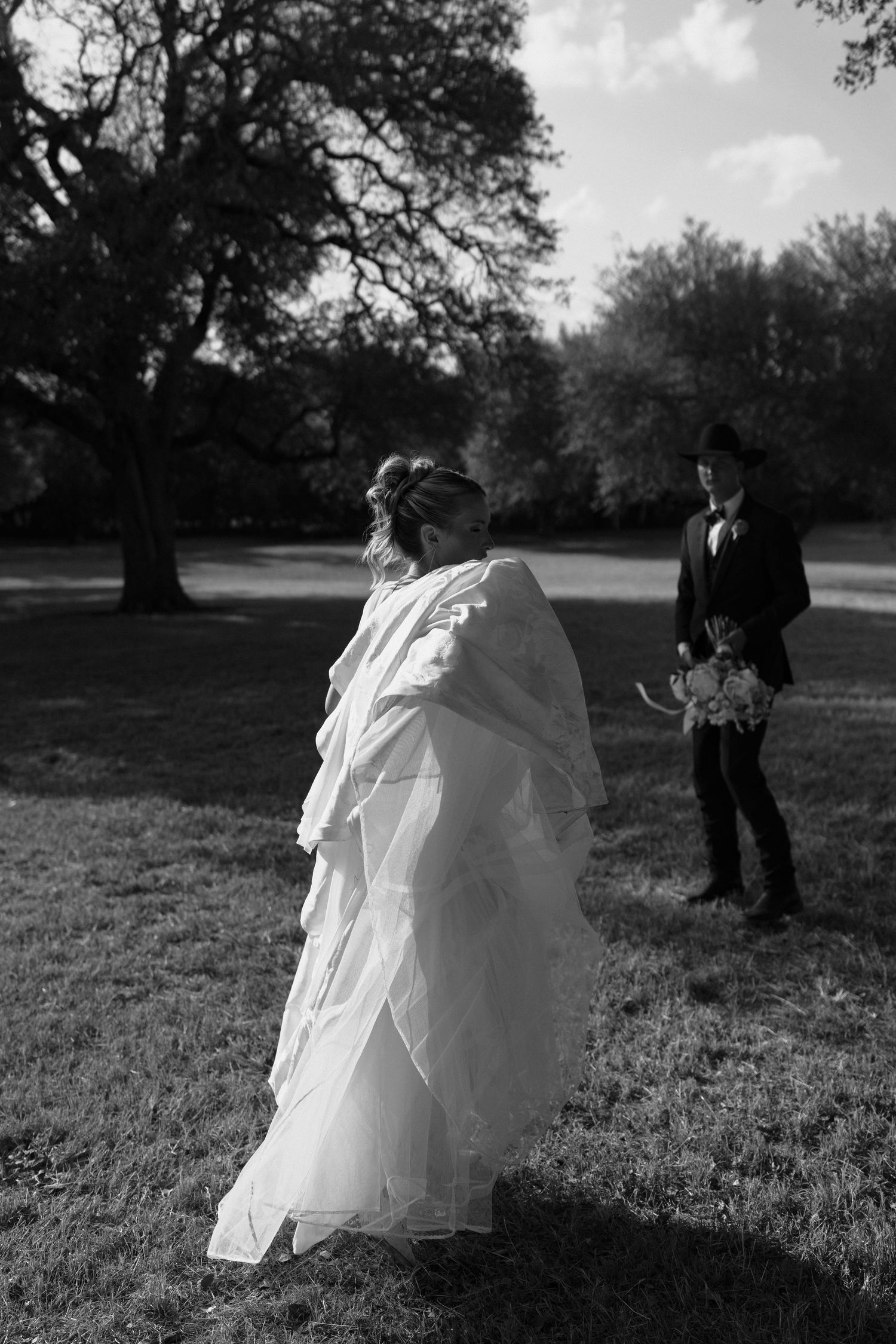 A black and white sequence of photos showing a couple walking in a park wearing formal attire.
