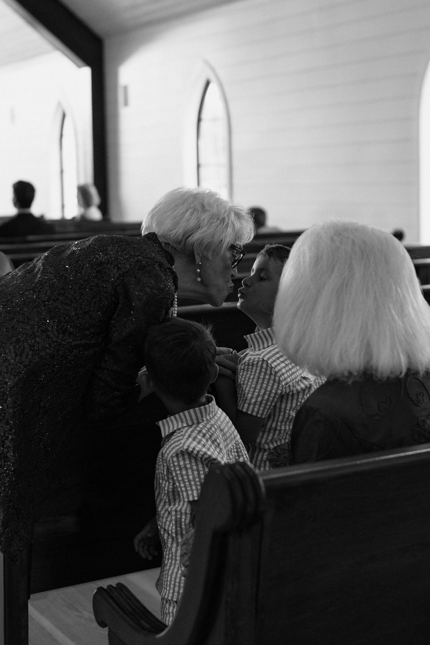 Black and white series showing church pew congregation during service viewed from behind.