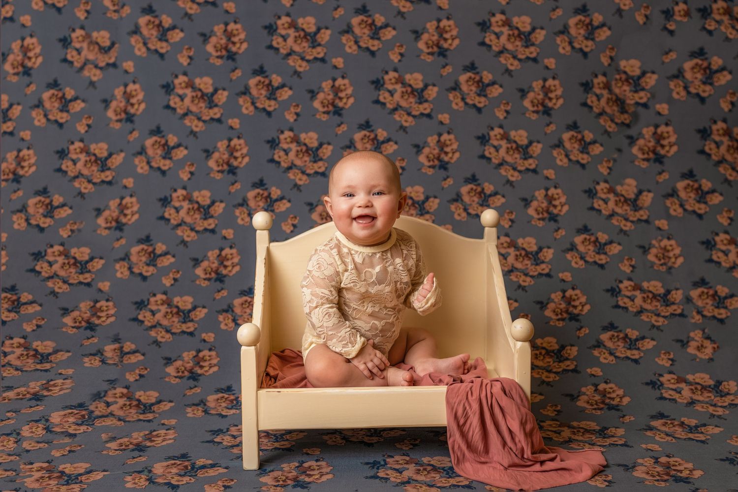 Autumn themed baby portrait session with decorative fall backdrop.