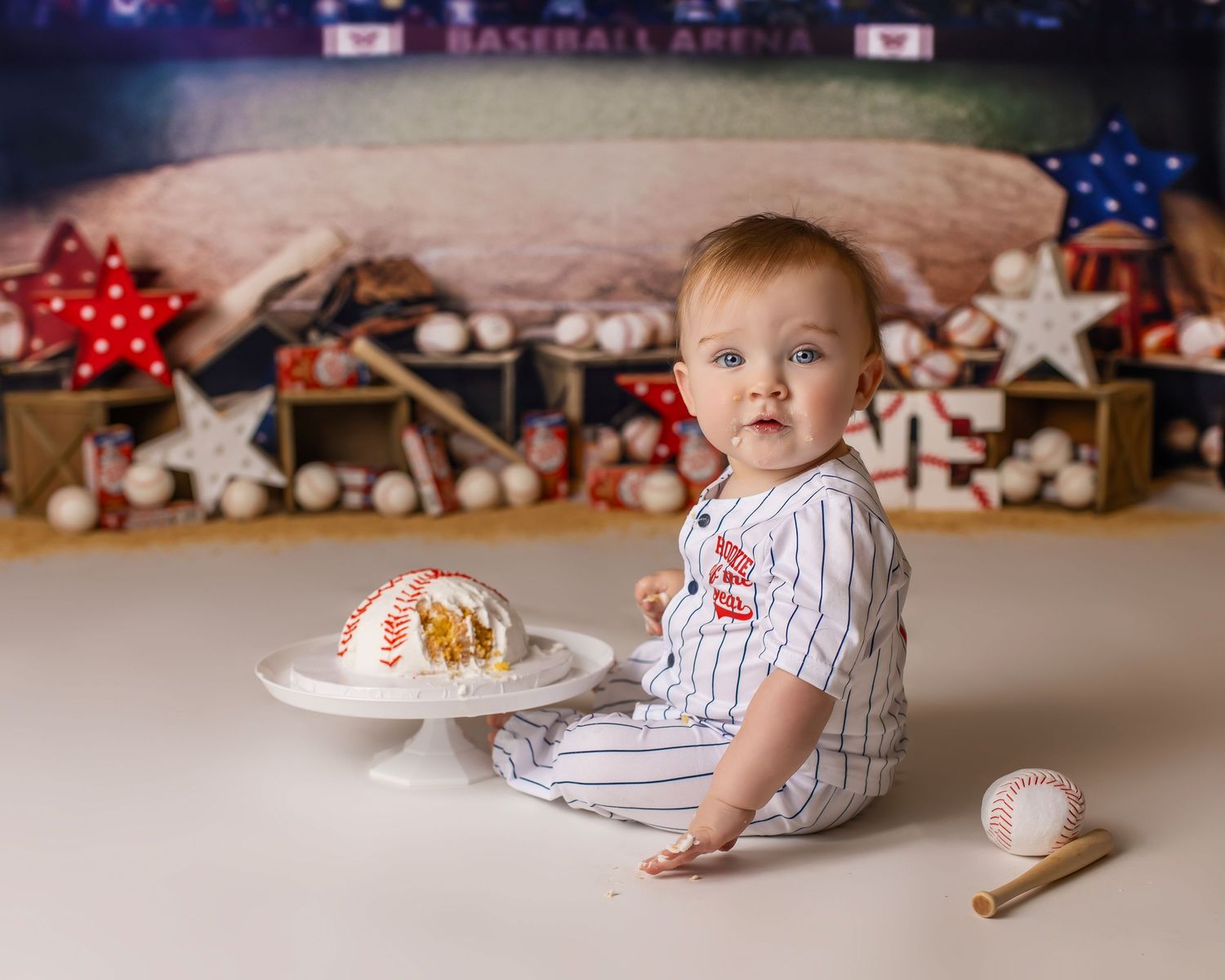 Baseball themed cake smash photo session with decorations and sports memorabilia.