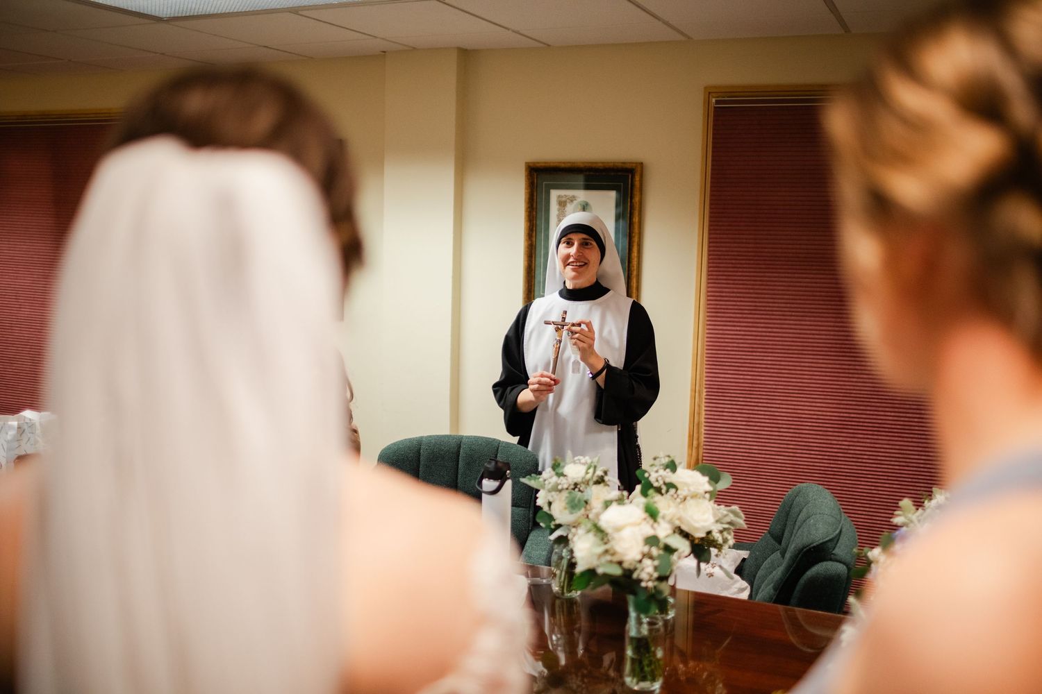 Wedding ceremony taking place in a church with floral decorations and soft lighting.