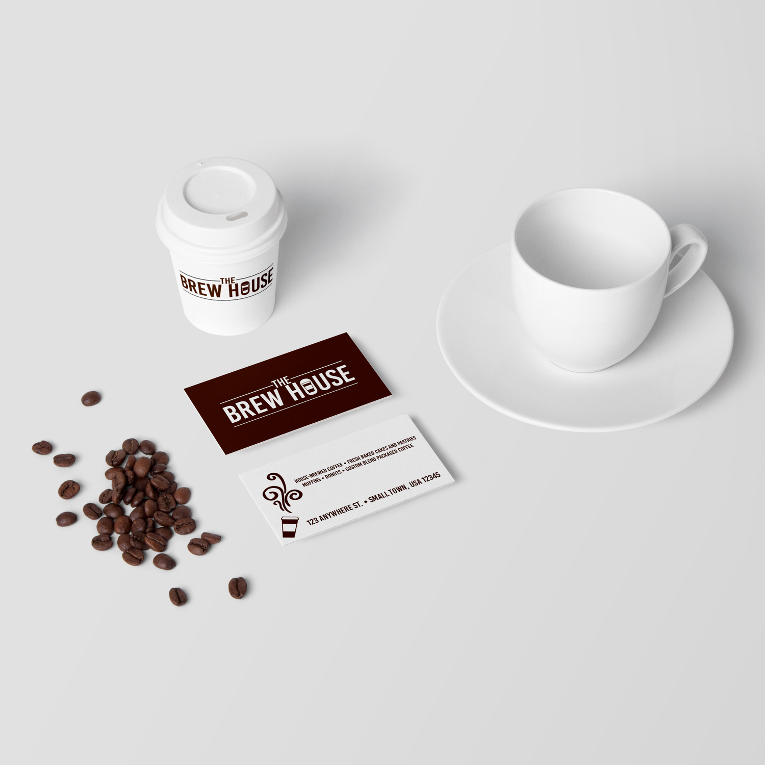 Coffee branding mockup with white cup, beans and business card on light background.