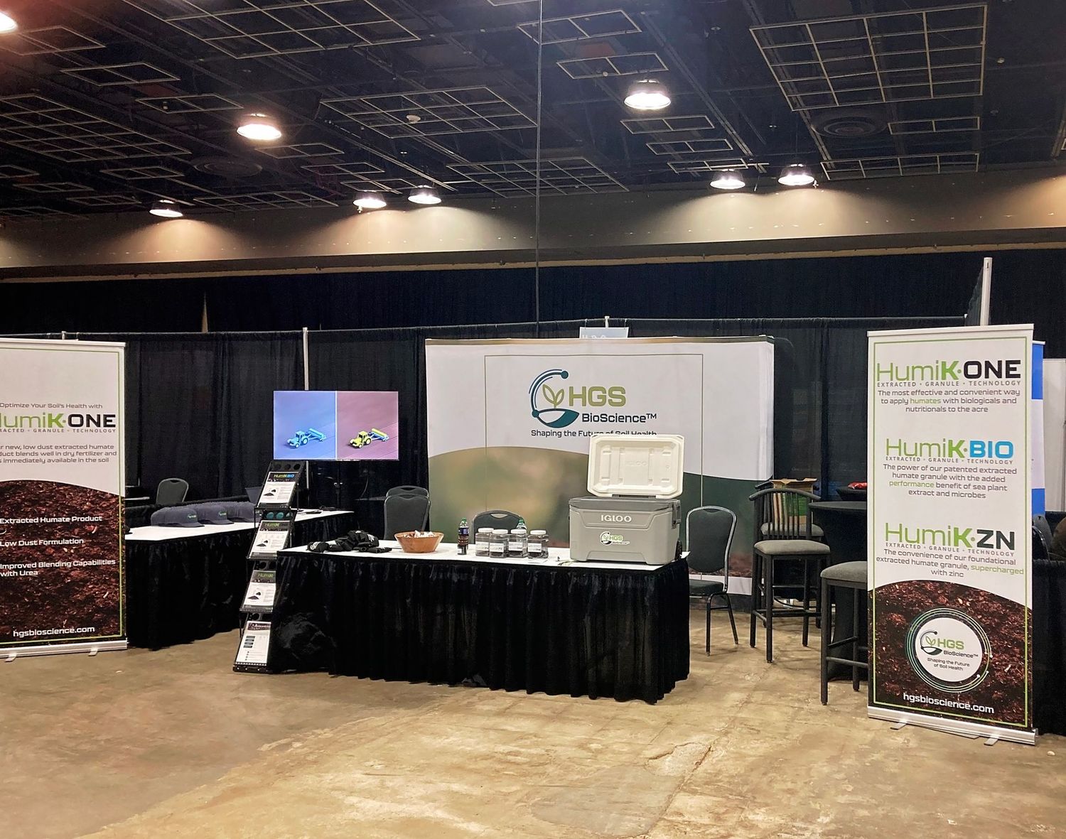 Empty convention center booth setup with banner stands and black table.