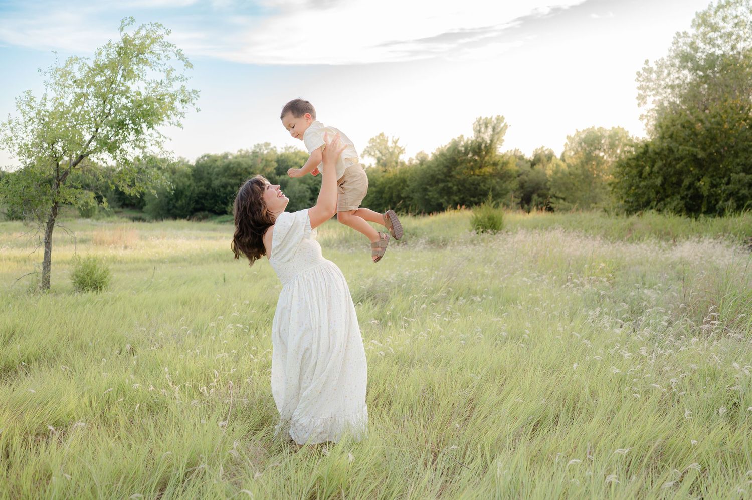 Pregnant Mother holding child in field for maternity photography in Edmond, OK