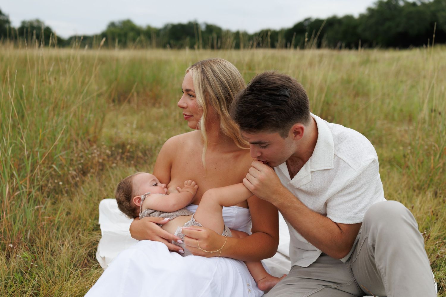 A couple embraces throughout a series of romantic photos taken in a golden grassy meadow at sunset.