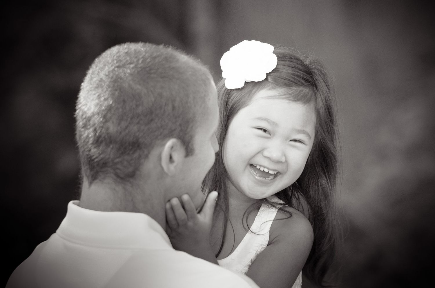 A heartwarming black and white candid image of a child sharing a joyful moment with a parent outdoors in Townsend TN.