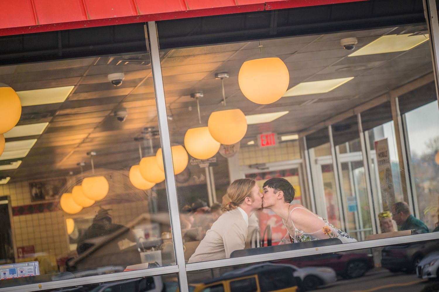 A couple share a romantic moment inside a restaurant with warm glowing pendant lights overhead by Gatlinburg TN Wedding Photographers.