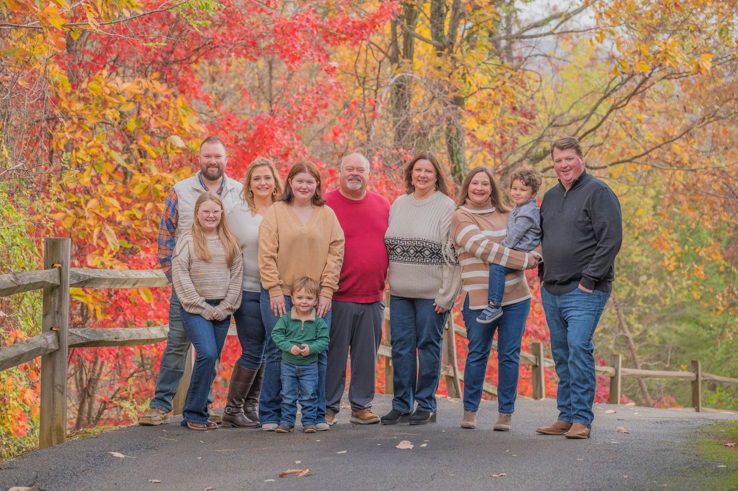 Sevierville Photographer family portrait surrounded by vibrant fall foliage in red, orange and yellow colors in Pigeon Forge.