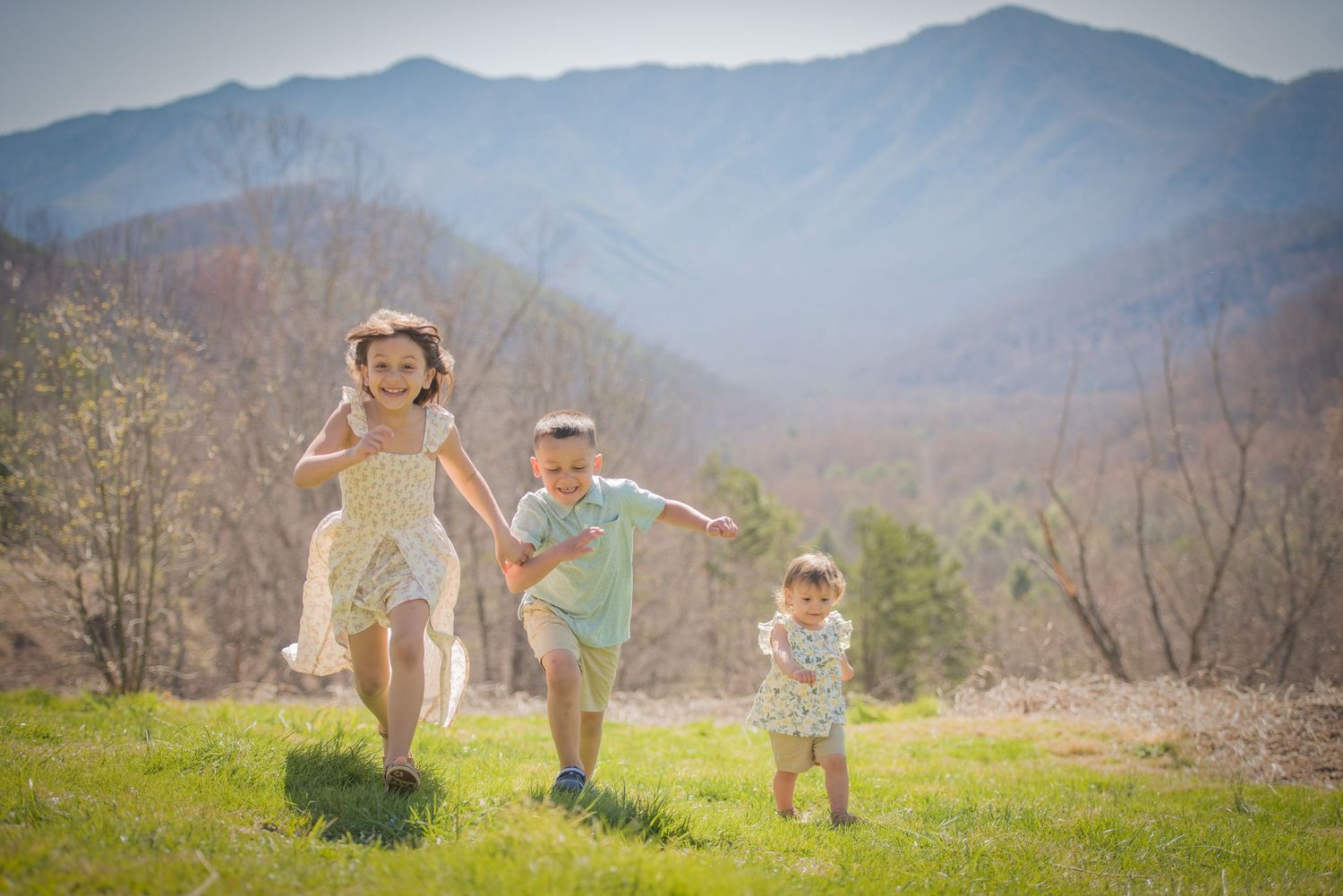 gatlinburg tn family photographer portrait of three kids playing against a mountain backdrop in Tennessee.