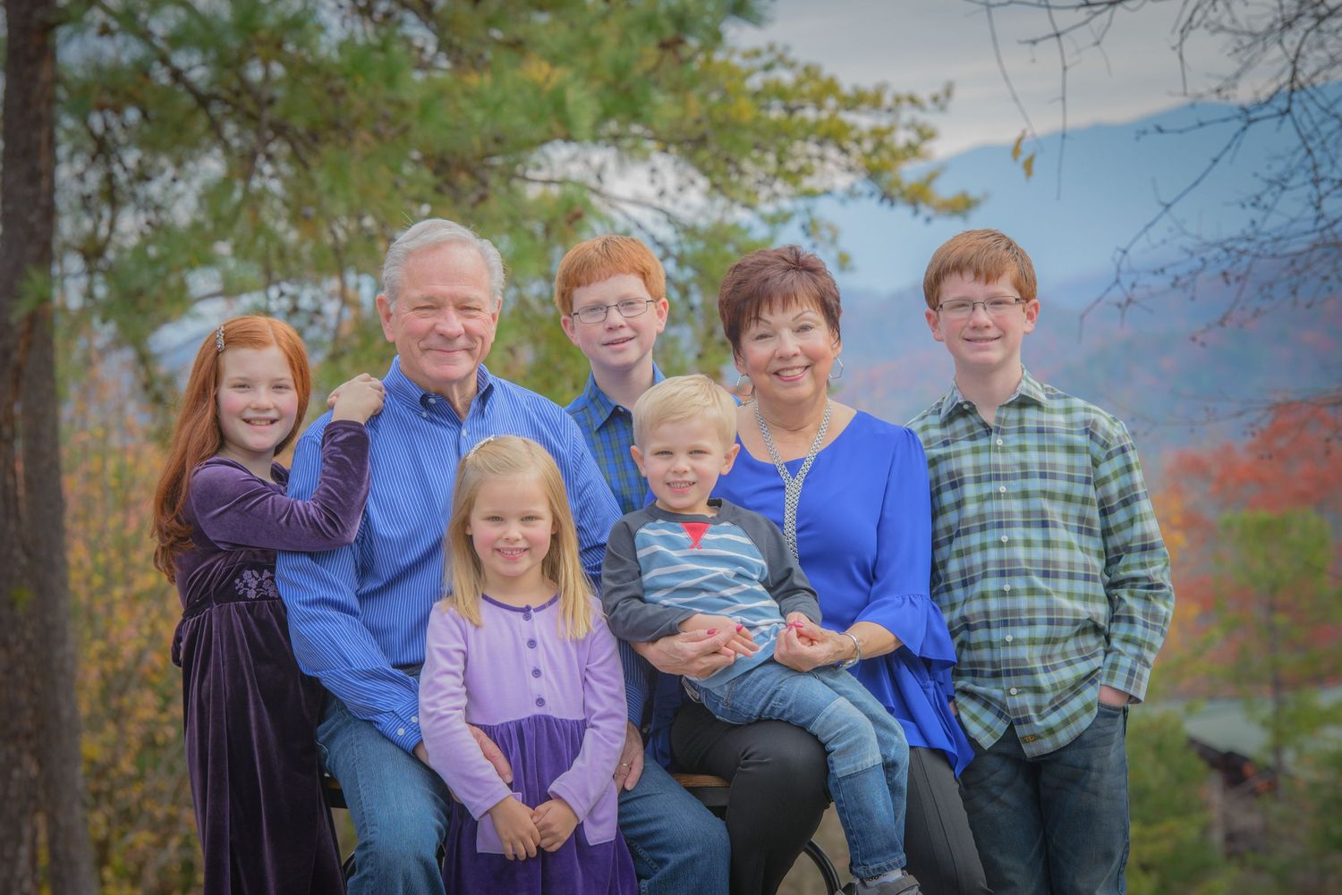 Gatlinburg Photographer portrait of a family group poses together outdoors in casual clothing against an autumn backdrop.