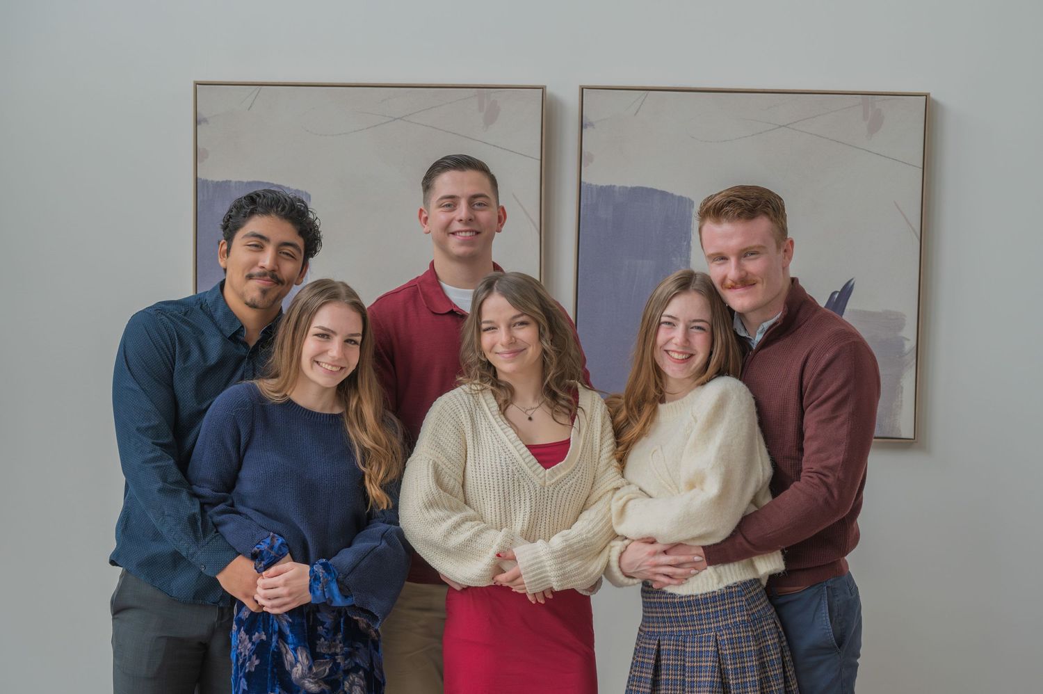 Group of six people in casual winter attire posing together a rental Airbnb in Gatlinburg TN .