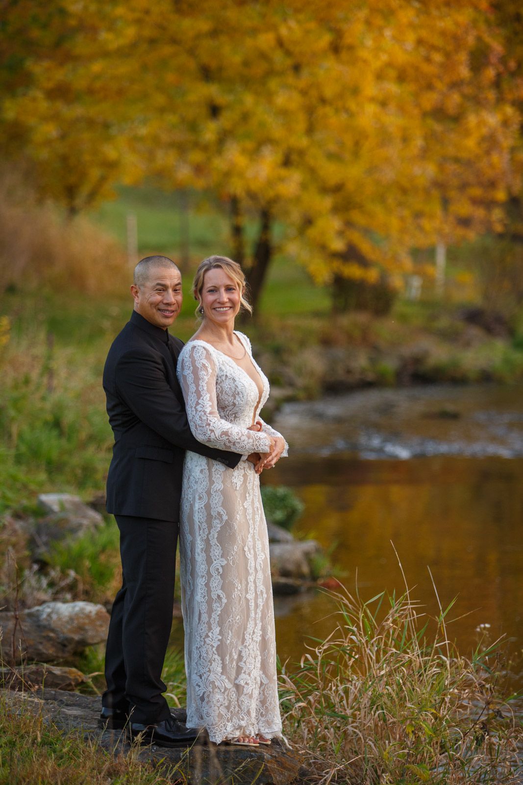 Fall wedding couple by a stream