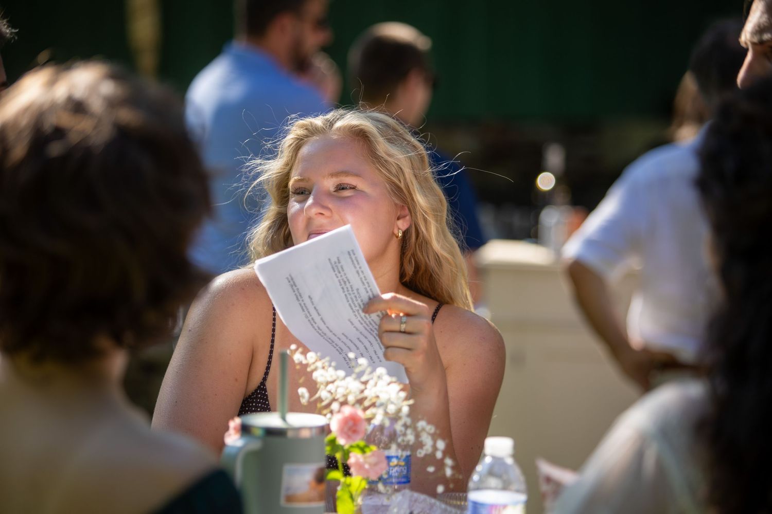 Young person enjoying a fresh salad at an outdoor restaurant table on a sunny day.