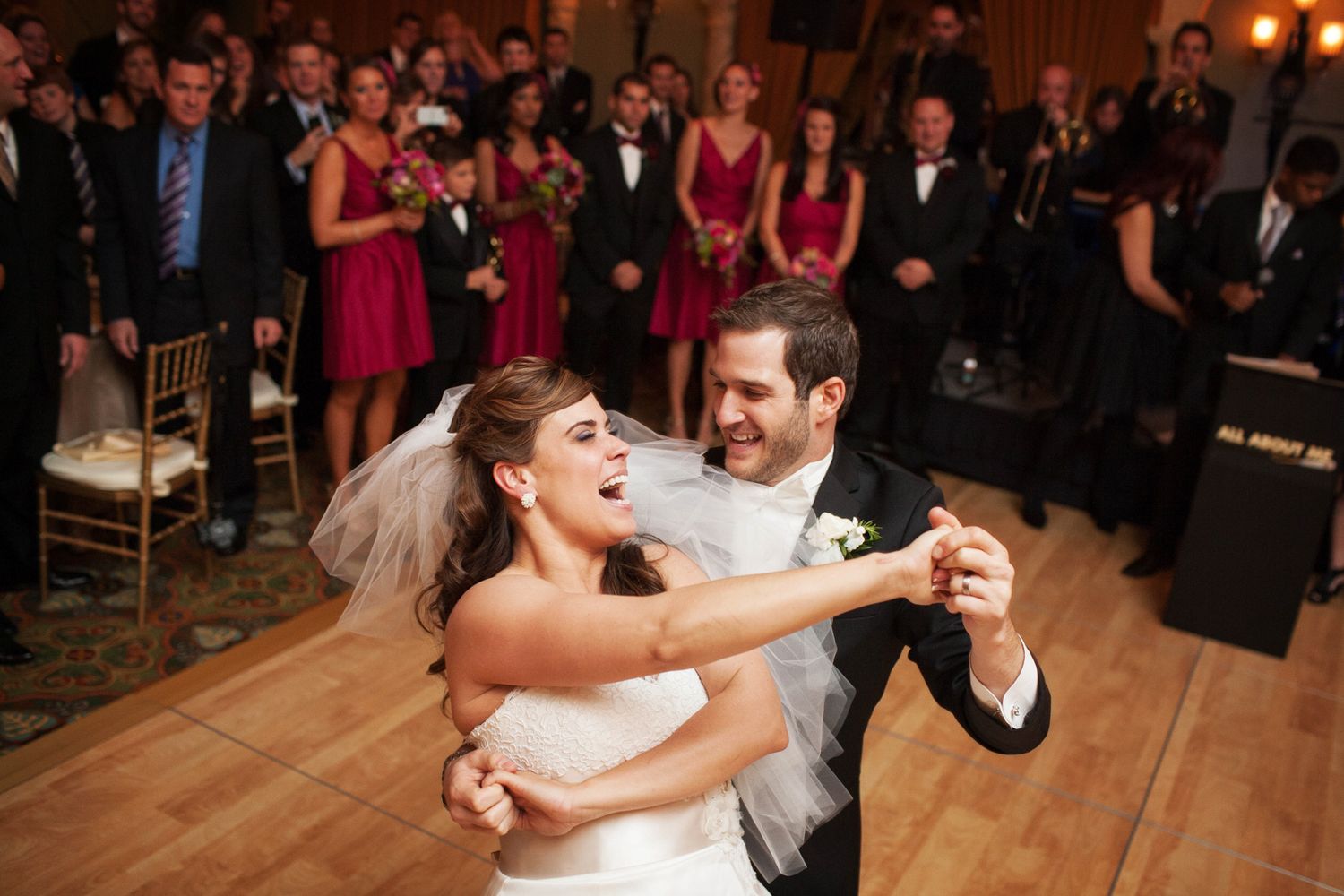 Wedding guests and the wedding party dance together during a lively reception celebration.