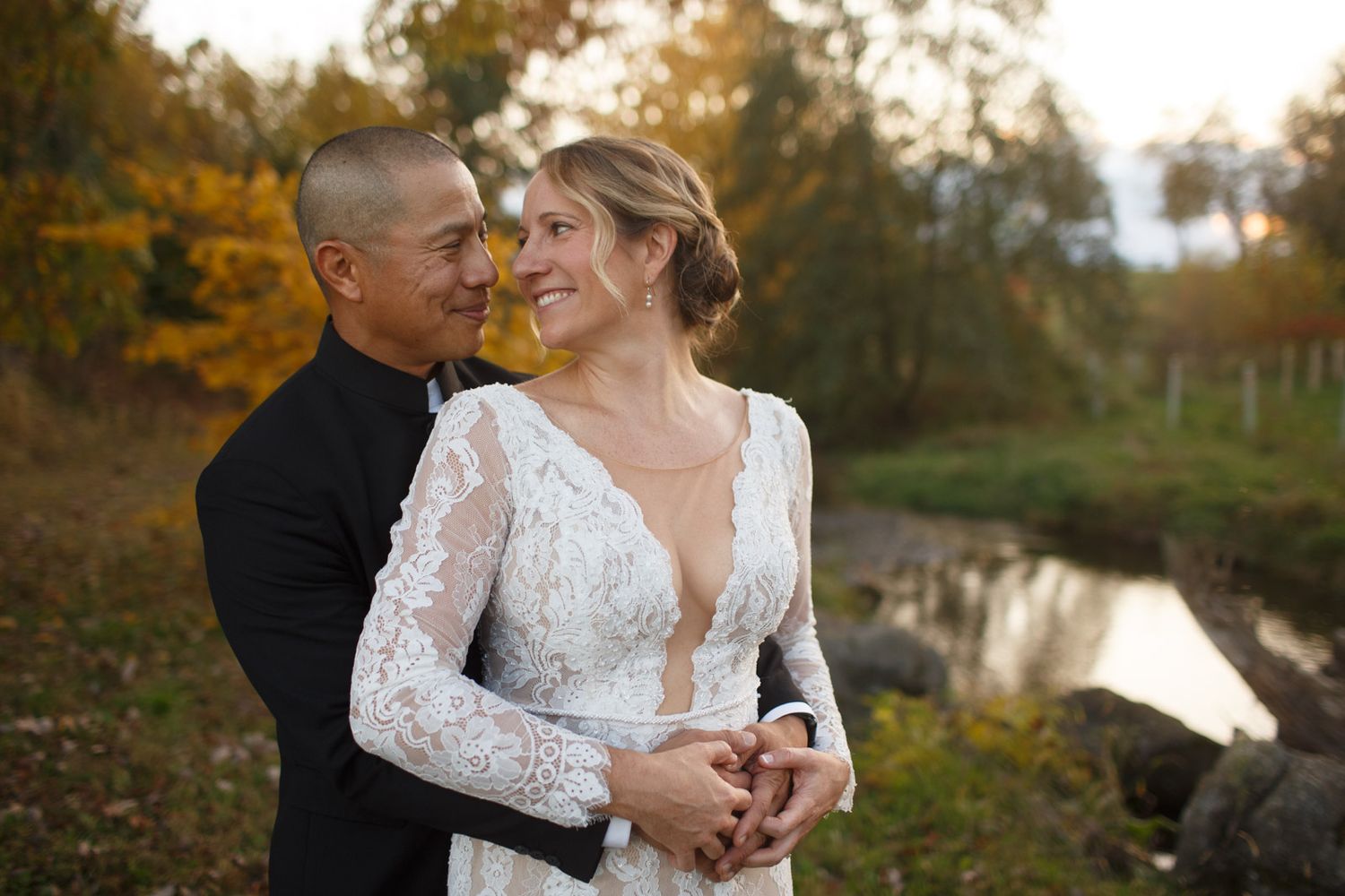 wedding couple smiling at each other in a pasture in the Fall