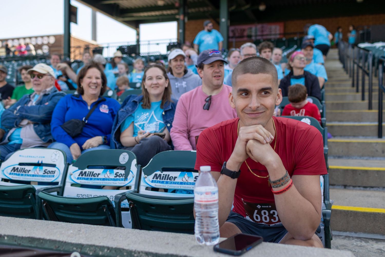 Spectators watch from stadium seats during an outdoor sporting event.