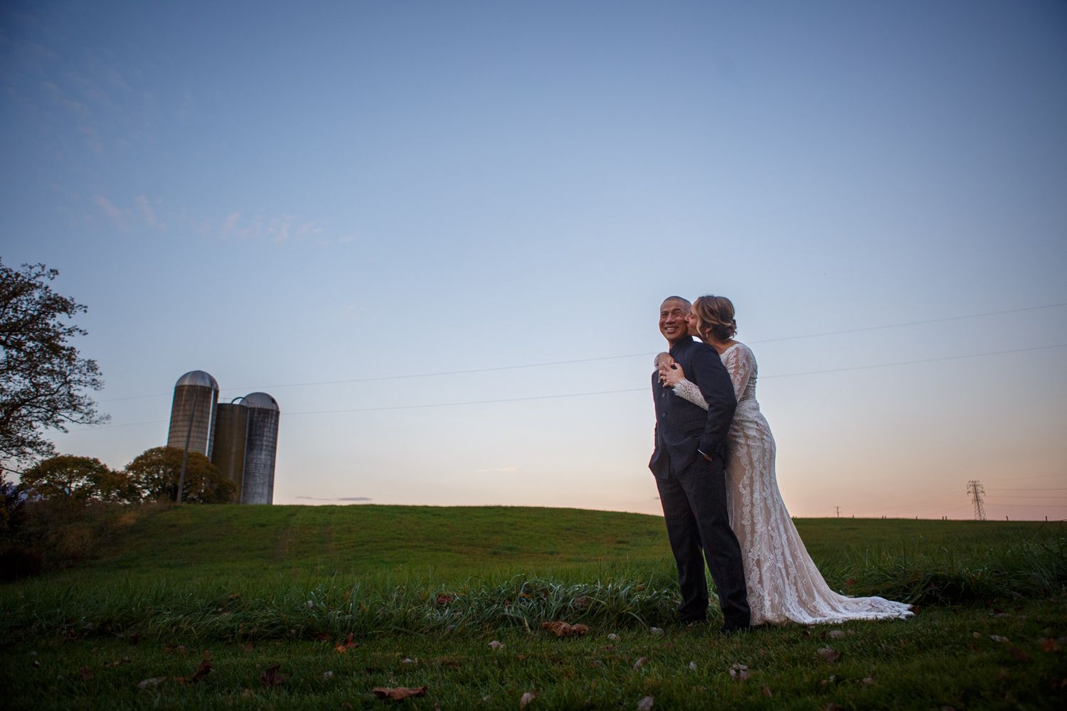 Bride and Groom at sunset on a farm with silos