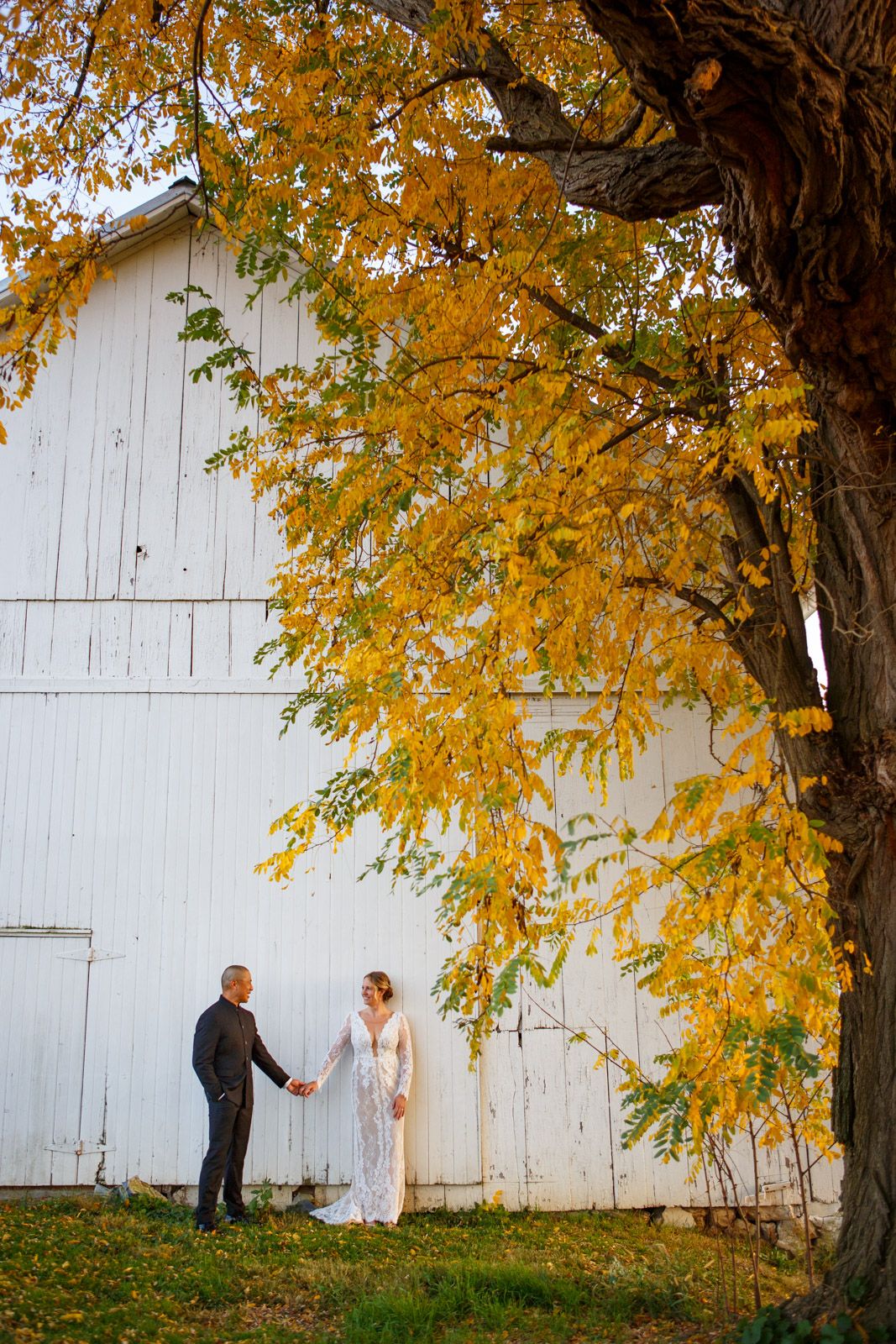couple on a farm by a white barn