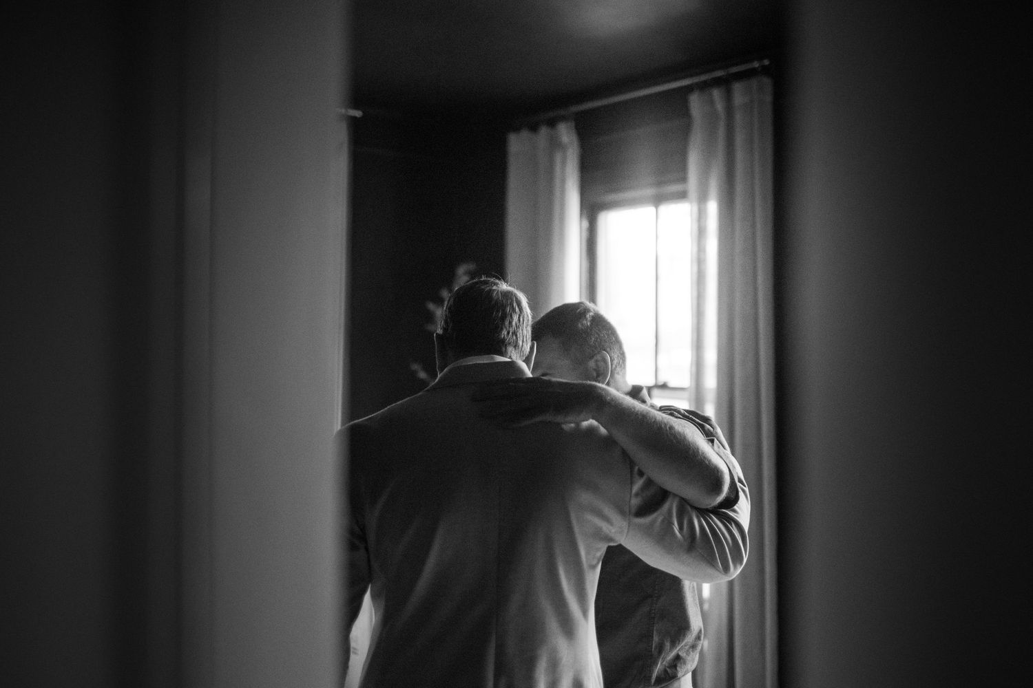 Black and white dramatic portraits capturing intimate familial moments by a window.